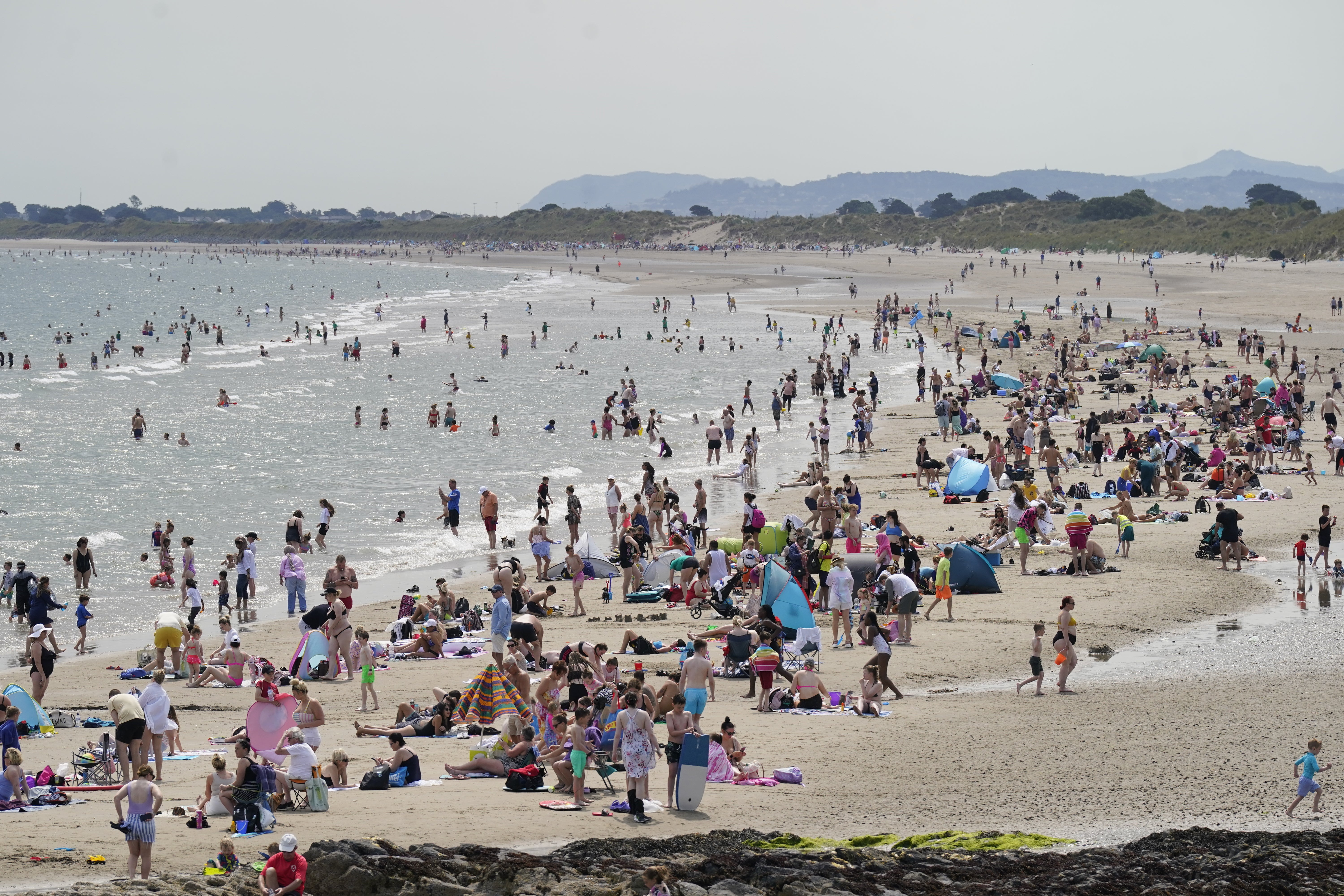 Crowds of people enjoying the sun on Portmarnock beach near Dublin (Niall Carson/PA)