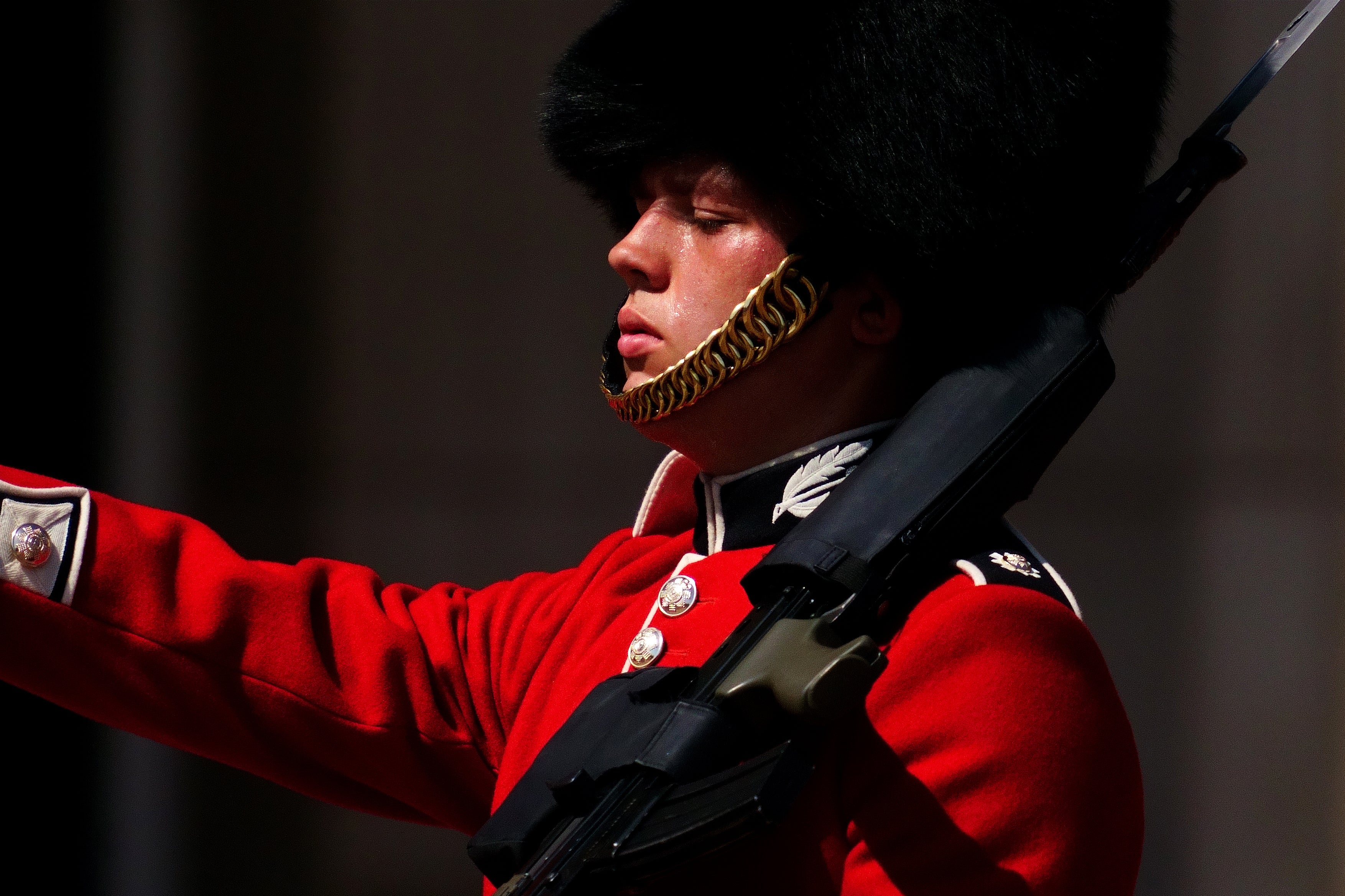 A member of F Company Scots Guards swelters in the heat during the Changing of the Guard ceremony on the forecourt of Buckingham Palace (Victoria Jones/PA)