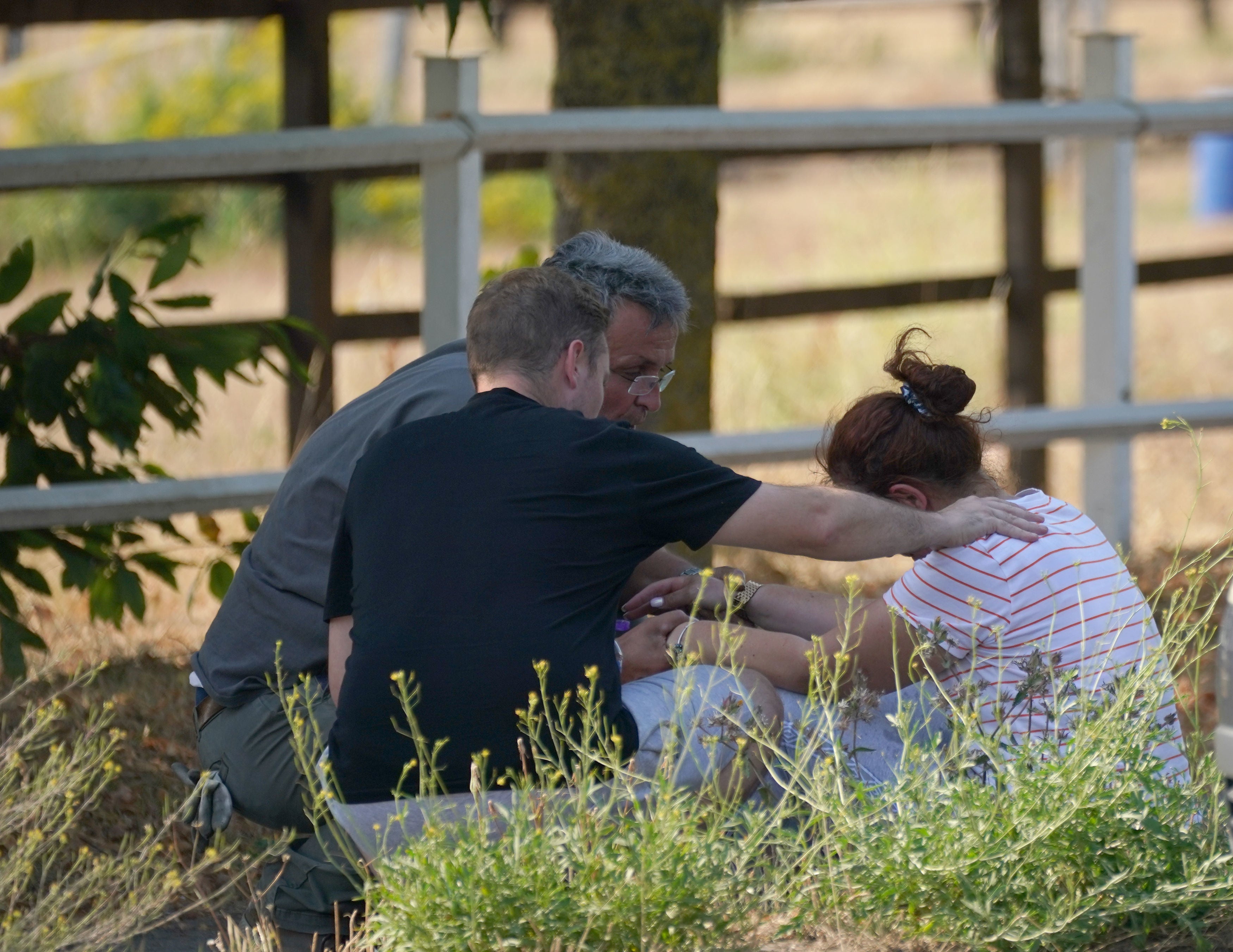 A woman is comforted close to the blaze in the village of Wennington where 100 firefighters tackled a fire on Tuesday