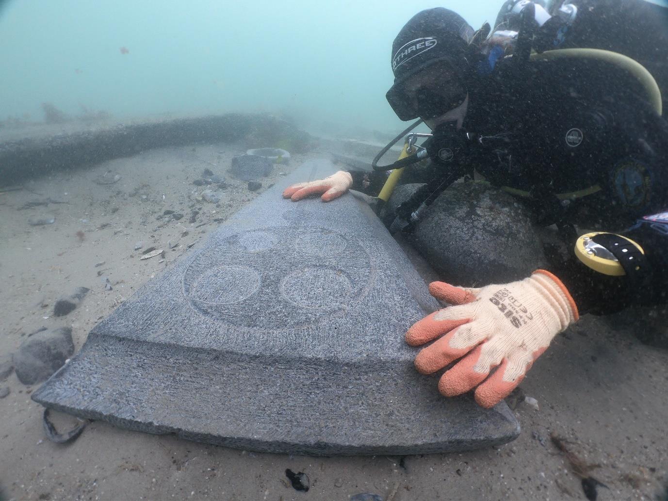 A diver looks at decorated gravestone near the Mortar wreck (Bournemouth University/PA)