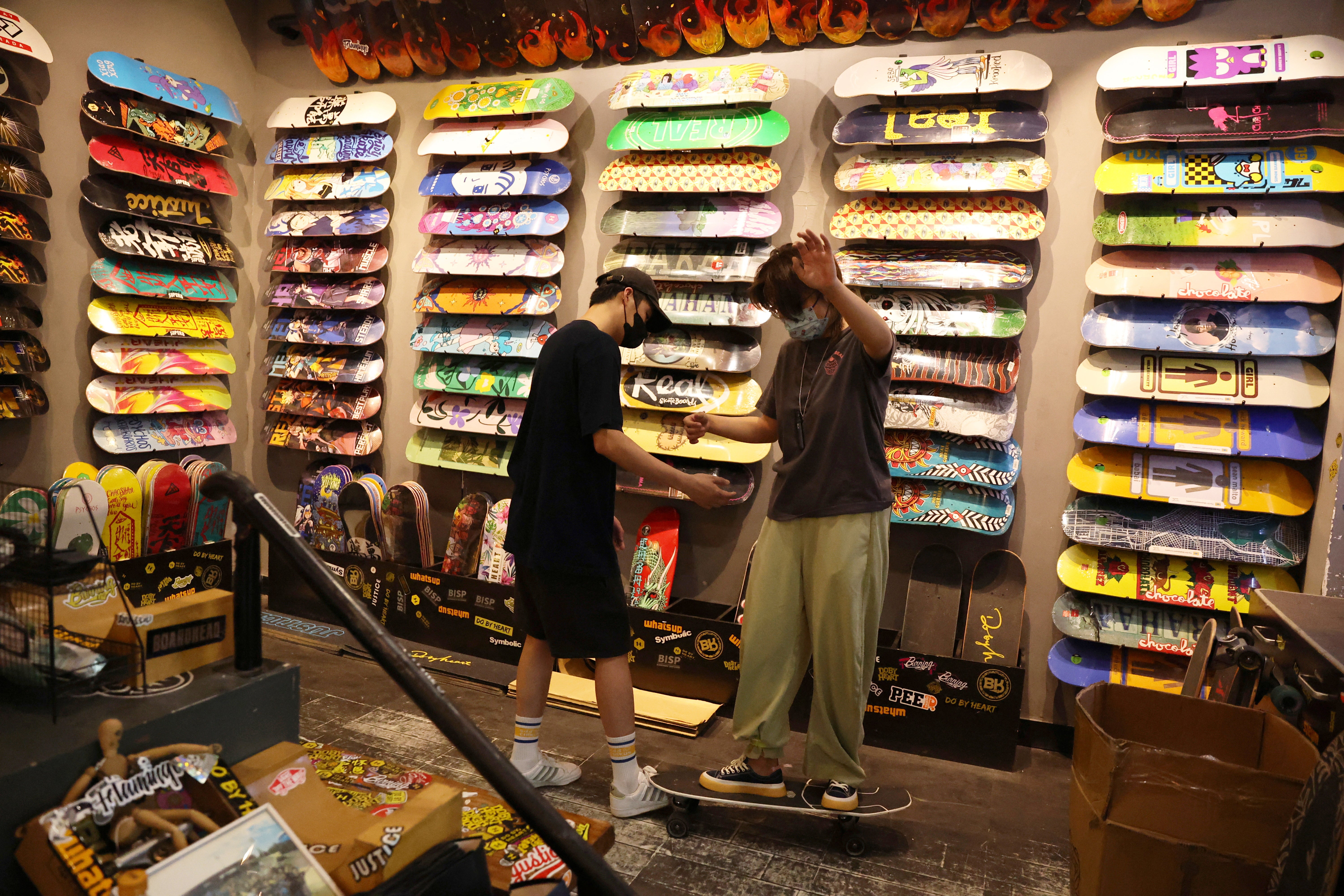 A customer tries on a surfskateboard at the Burning Ice Skateboard shop, in Beijing