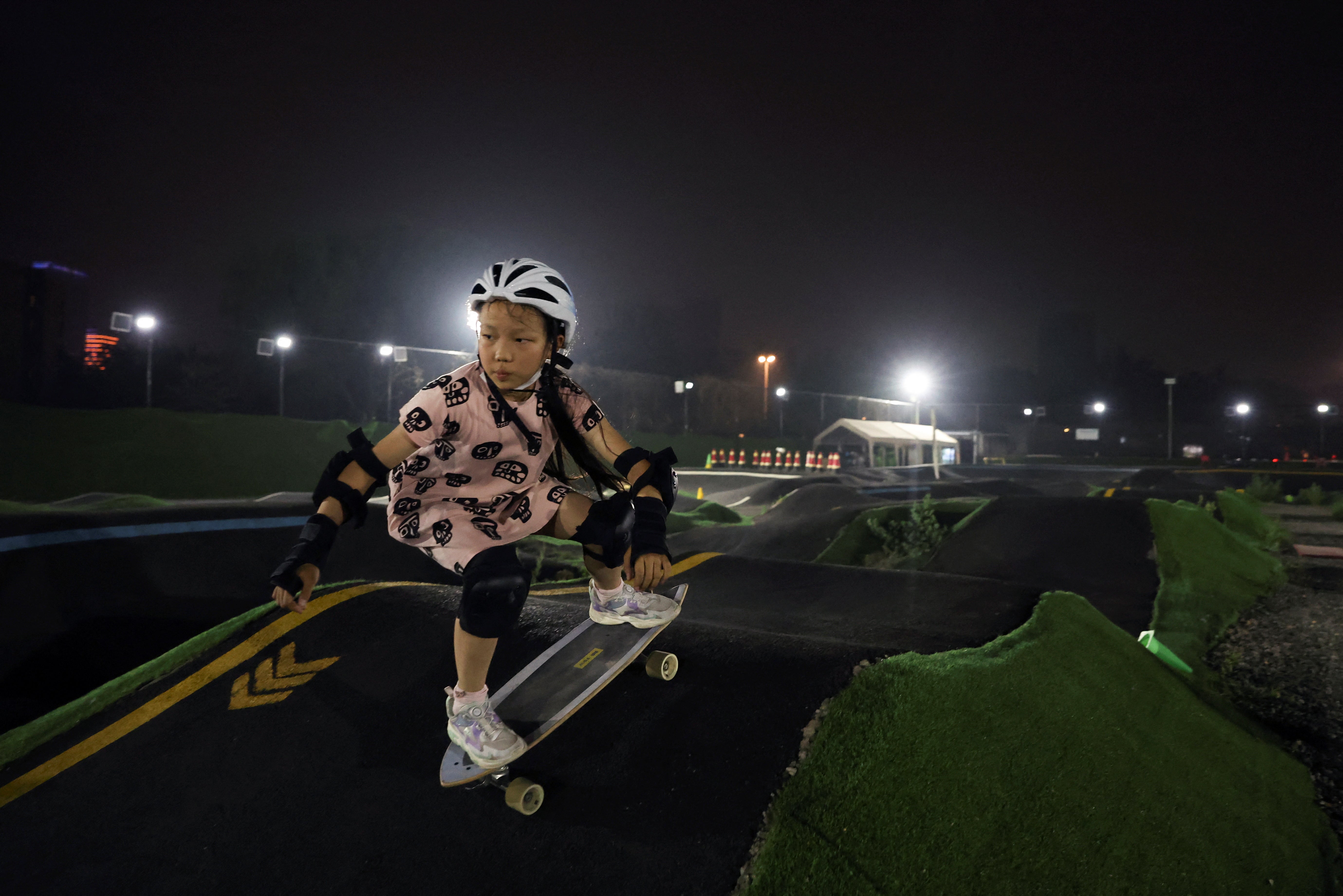 Zhang Qianqian, 9, a junior member of Beijing Girls Surfskating Community, rides a skateboard at a pump track in Beijing
