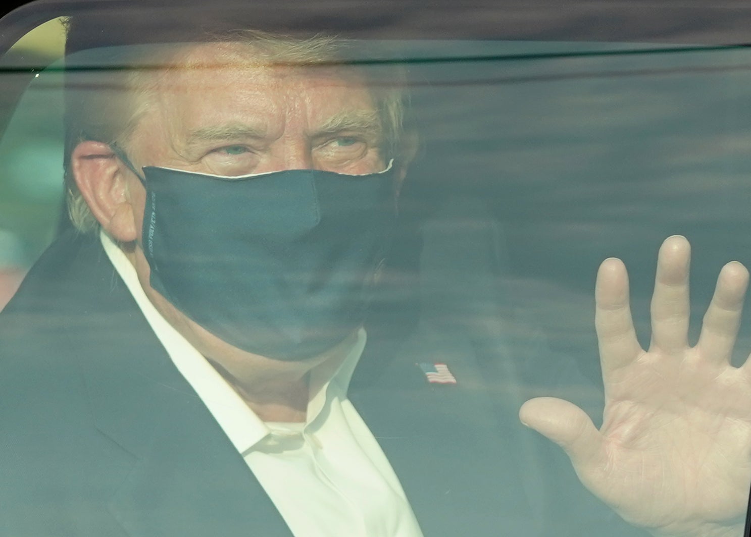 A car with US President Trump drives past supporters in a motorcade outside of Walter Reed Medical Center in Bethesda, Maryland on October 4, 2020