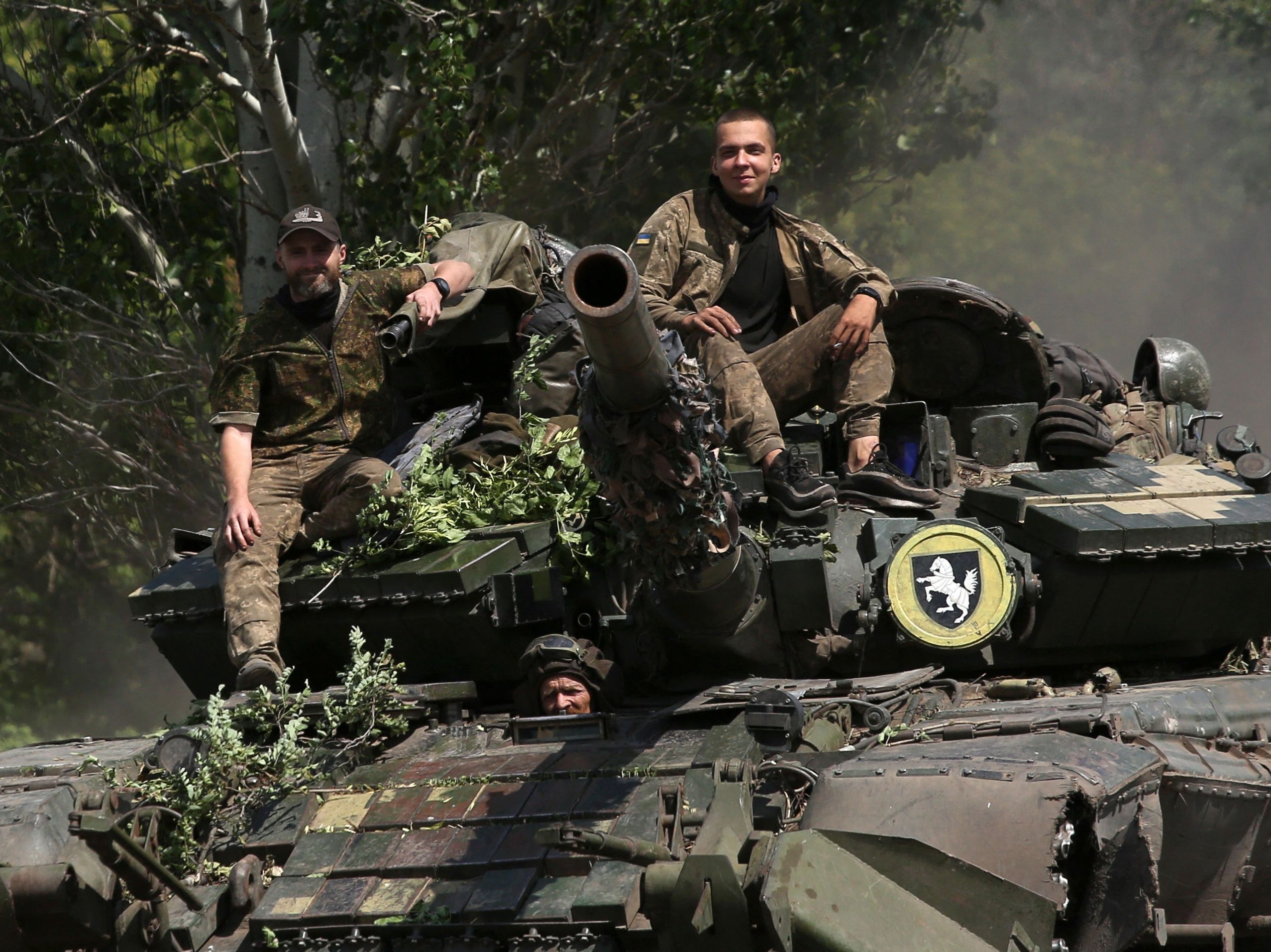 Ukrainian soldiers ride a tank on a road in the Donetsk region near the front line between Russian and Ukrainian forces