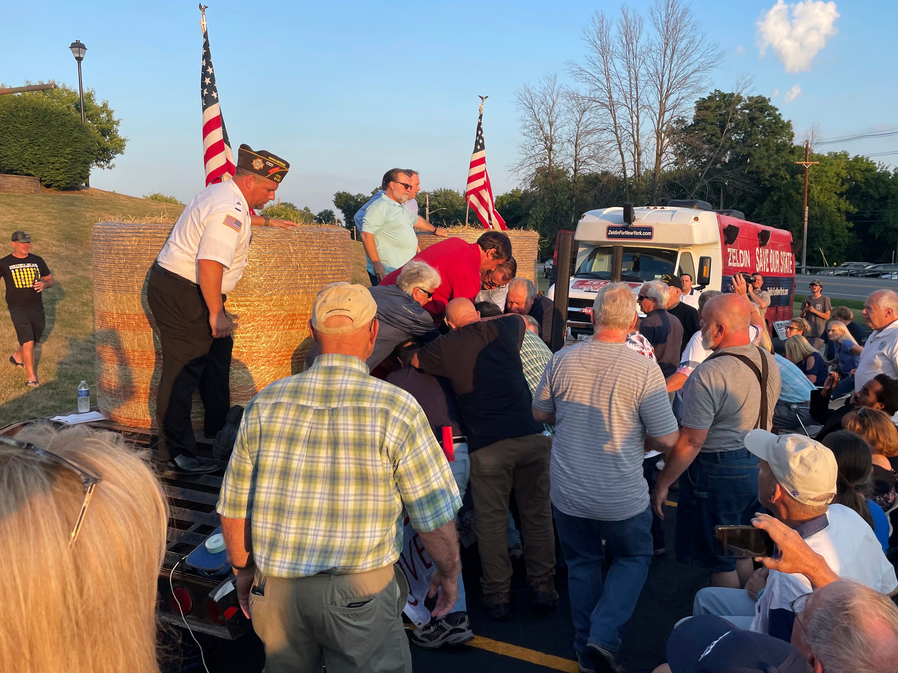 In this photo provided by Ian Winner, people subdue a person who assaulted U.S. Rep. Lee Zeldin, the Republican candidate for New York governor, at a campaign appearance Thursday, July 21, 2022, in Fairport, N.Y. Zeldin escaped serious injury