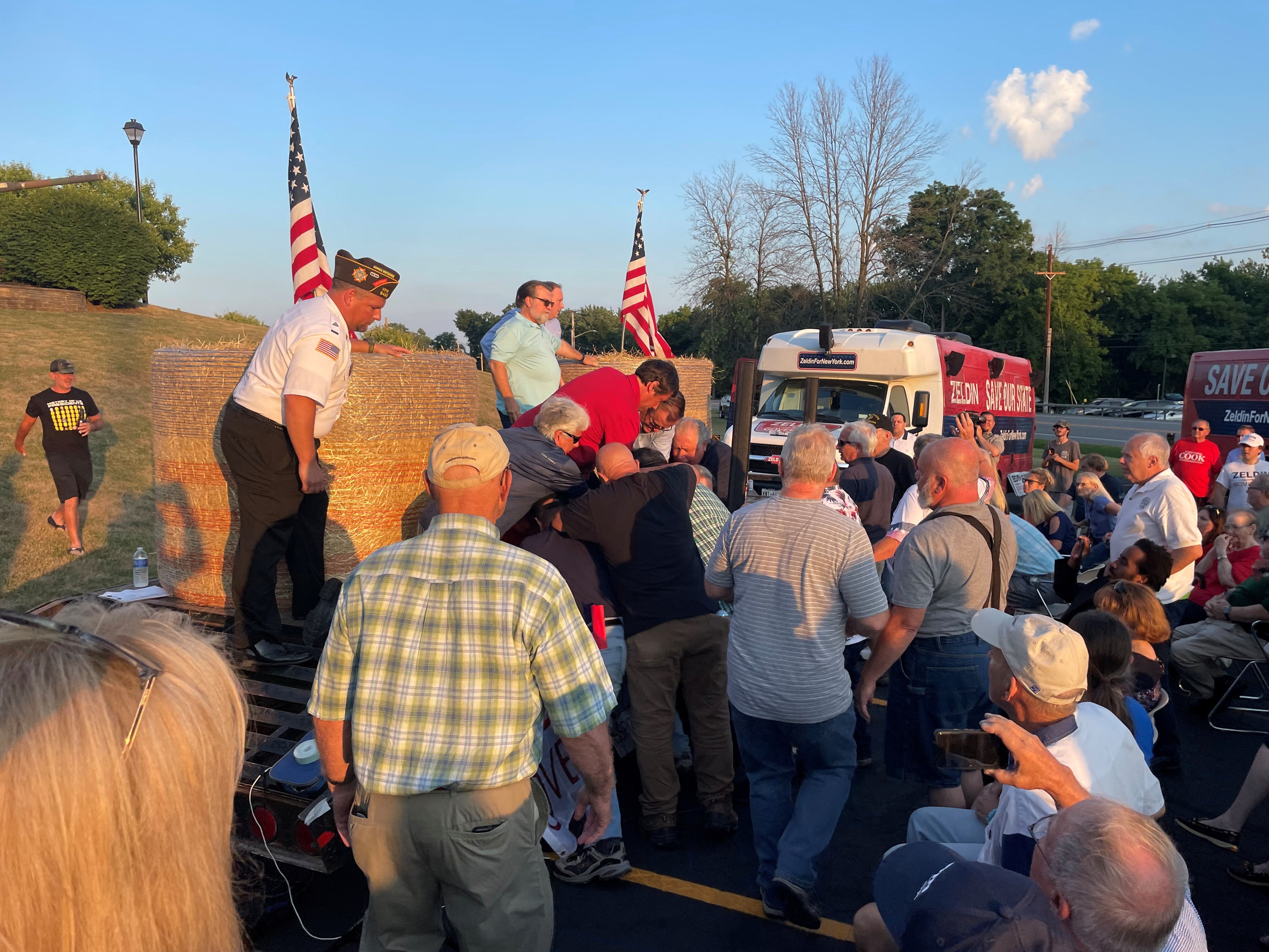 A group of people, attending Congressman Lee Zeldin's stump speech, gather around, what the photographer says was the attacker, after an alleged attack on Zeldin during his stump speech, in Fairport, New York, United States, July 21, 2022