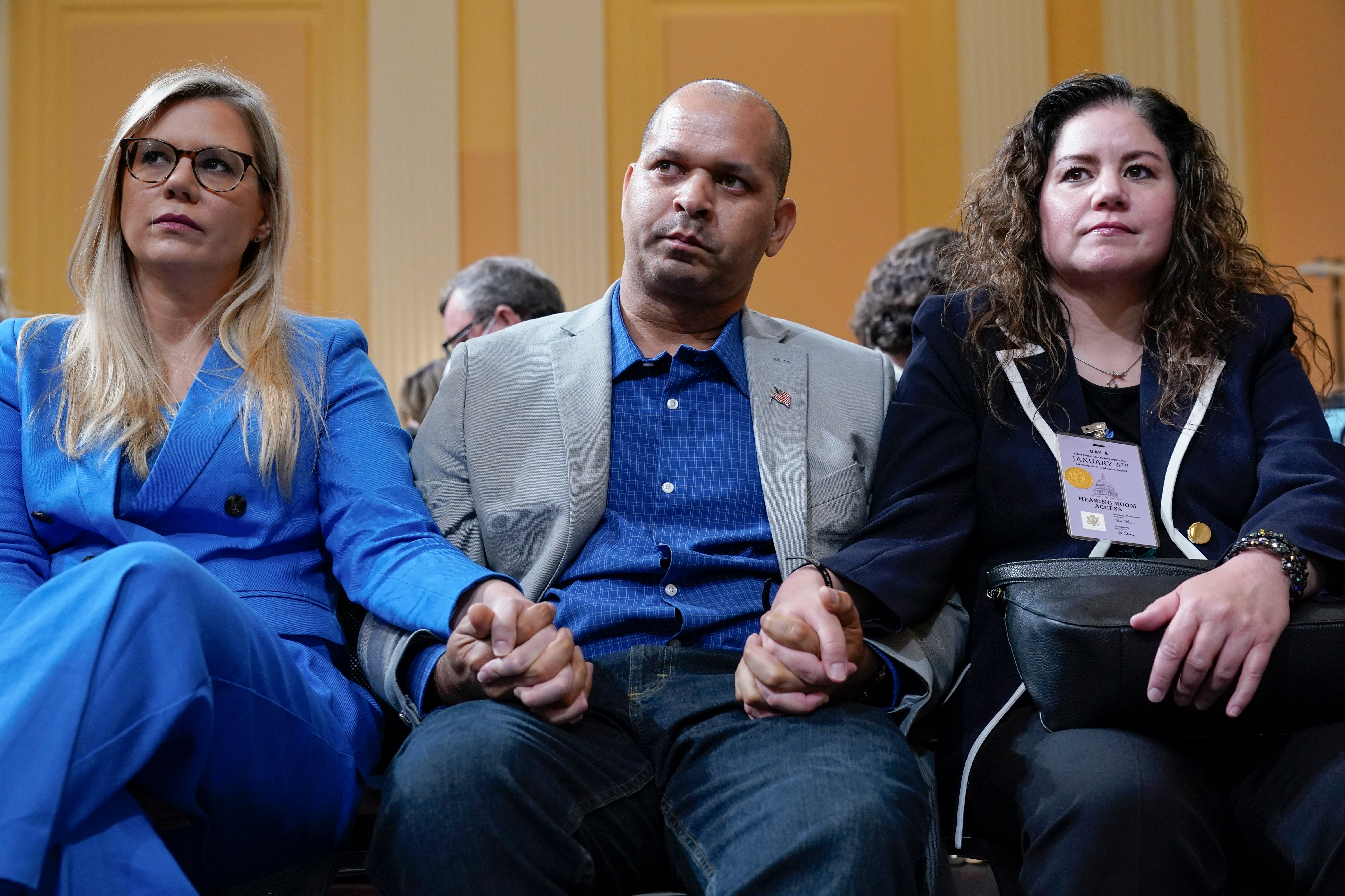 Erin Smith, widow of Washington Metropolitan Police Department officer Jeffrey Smith, US Capitol Police Sgt. Aquilino Gonell and Sandra Garza, the long-time partner of fallen Capitol Police Officer Brian Sicknick, hold hands as the House select committee investigating the Jan. 6 attack