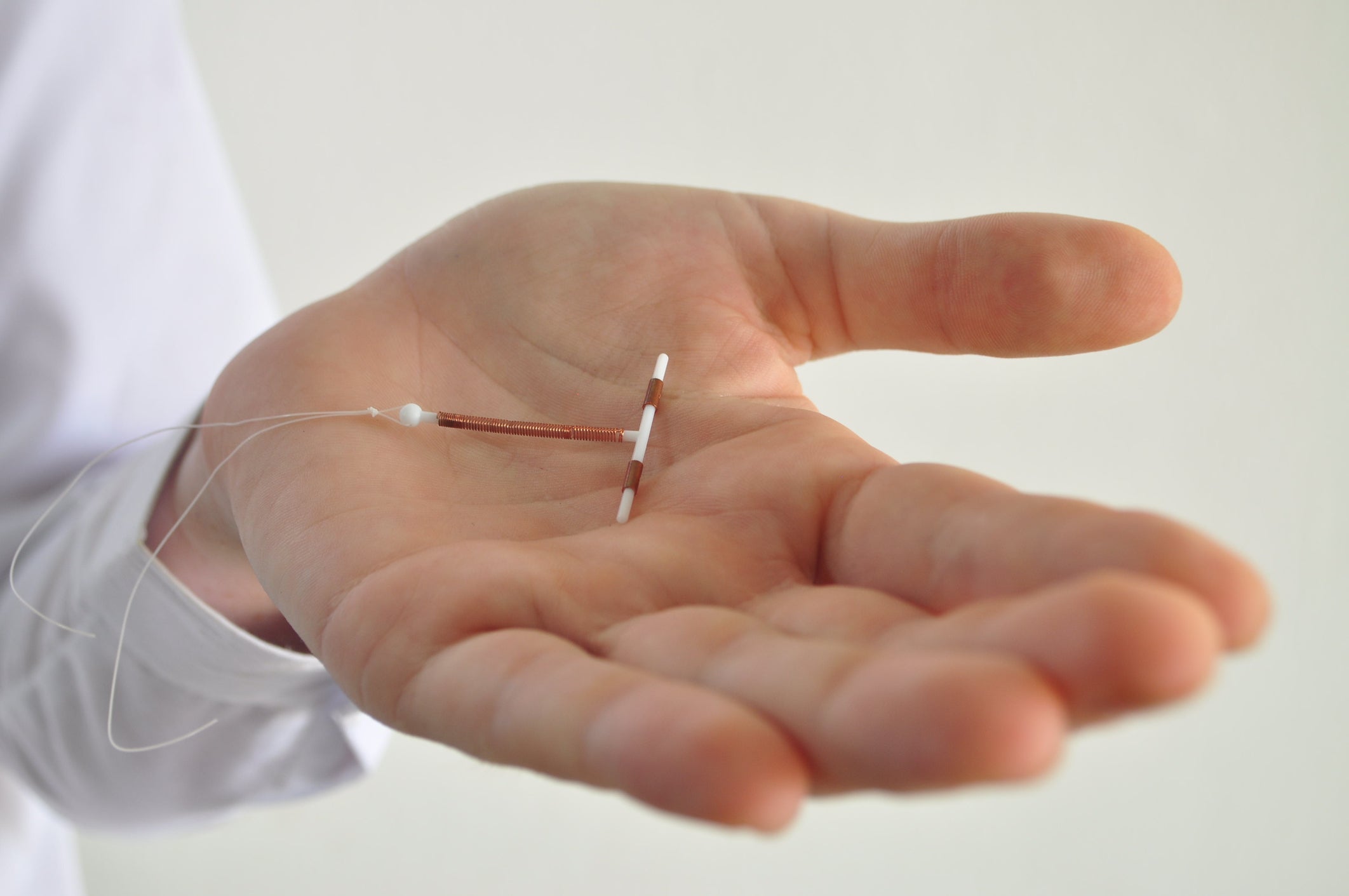 An IUD birth control copper coil device in hand,