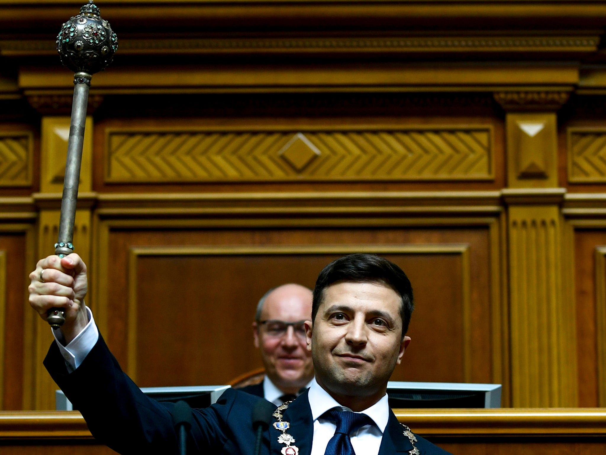 Zelensky raises the presidential mace on taking the oath of allegiance to the people of Ukraine in 2019