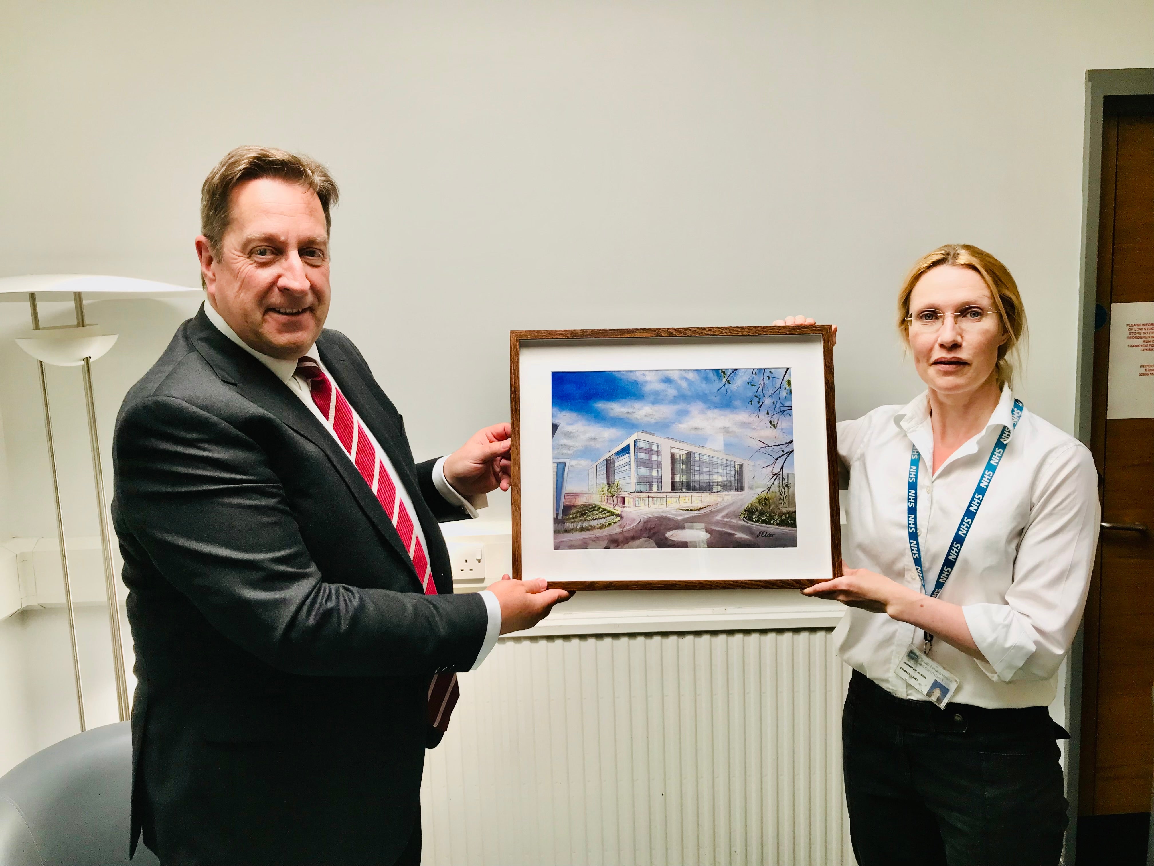 South Eastern Health and Social Care Trust acting chairman Jonathan Patton is presented with a painting of the new inpatient ward block at the Ulster Hospital by its artist, Dr Jennifer Elder (South Eastern HSC Trust/PA)