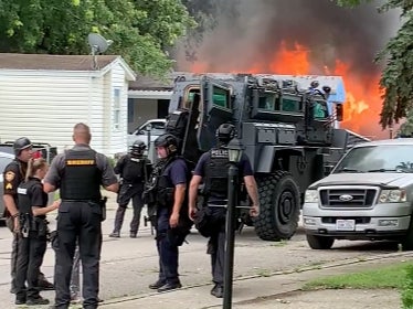 A mobile home caught fire and a police officer was shot inside the residence