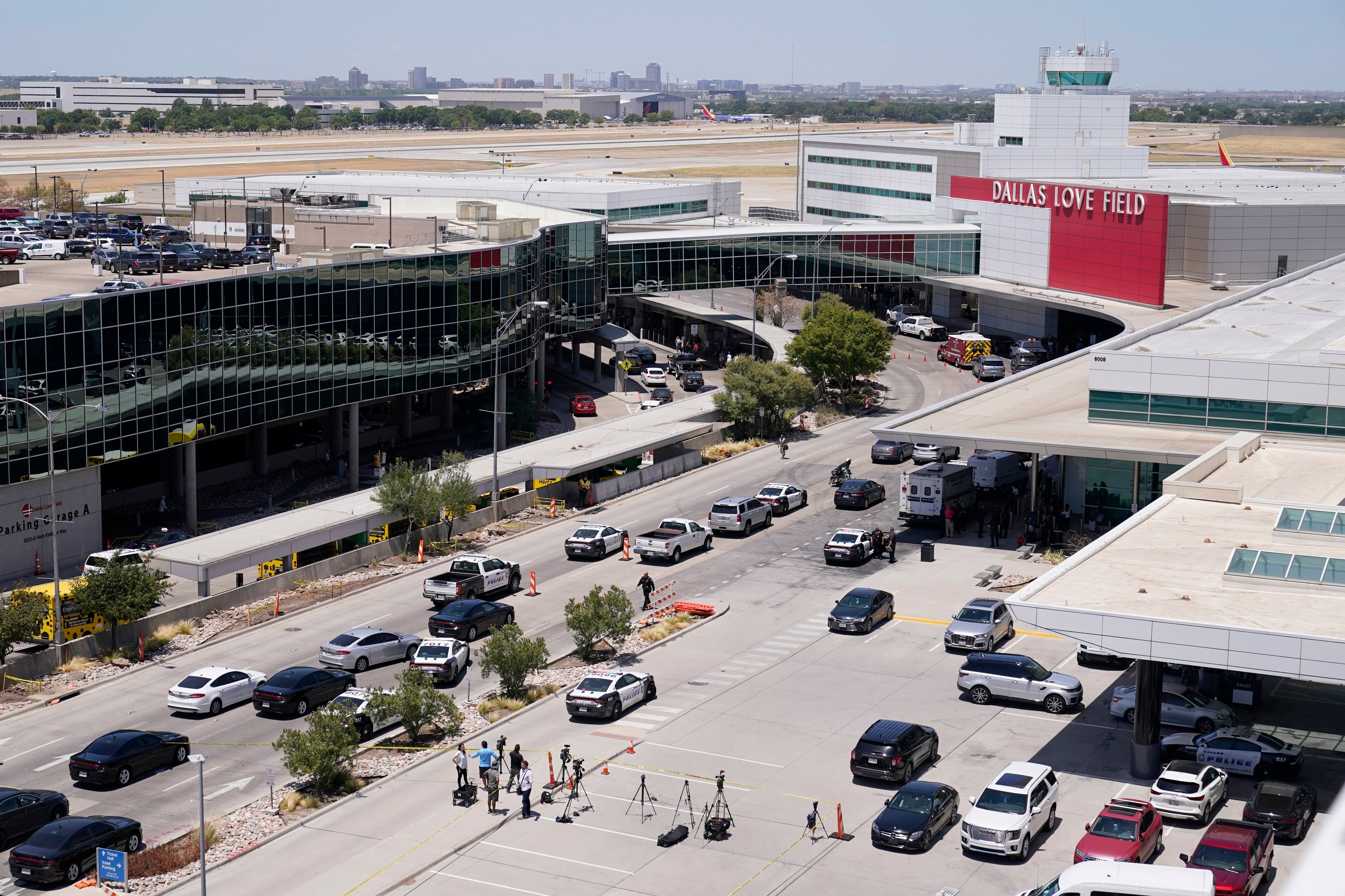 Emergency responders gather near the main entrance at Dallas Love Field in Dallas, Monday, July 25, 2022