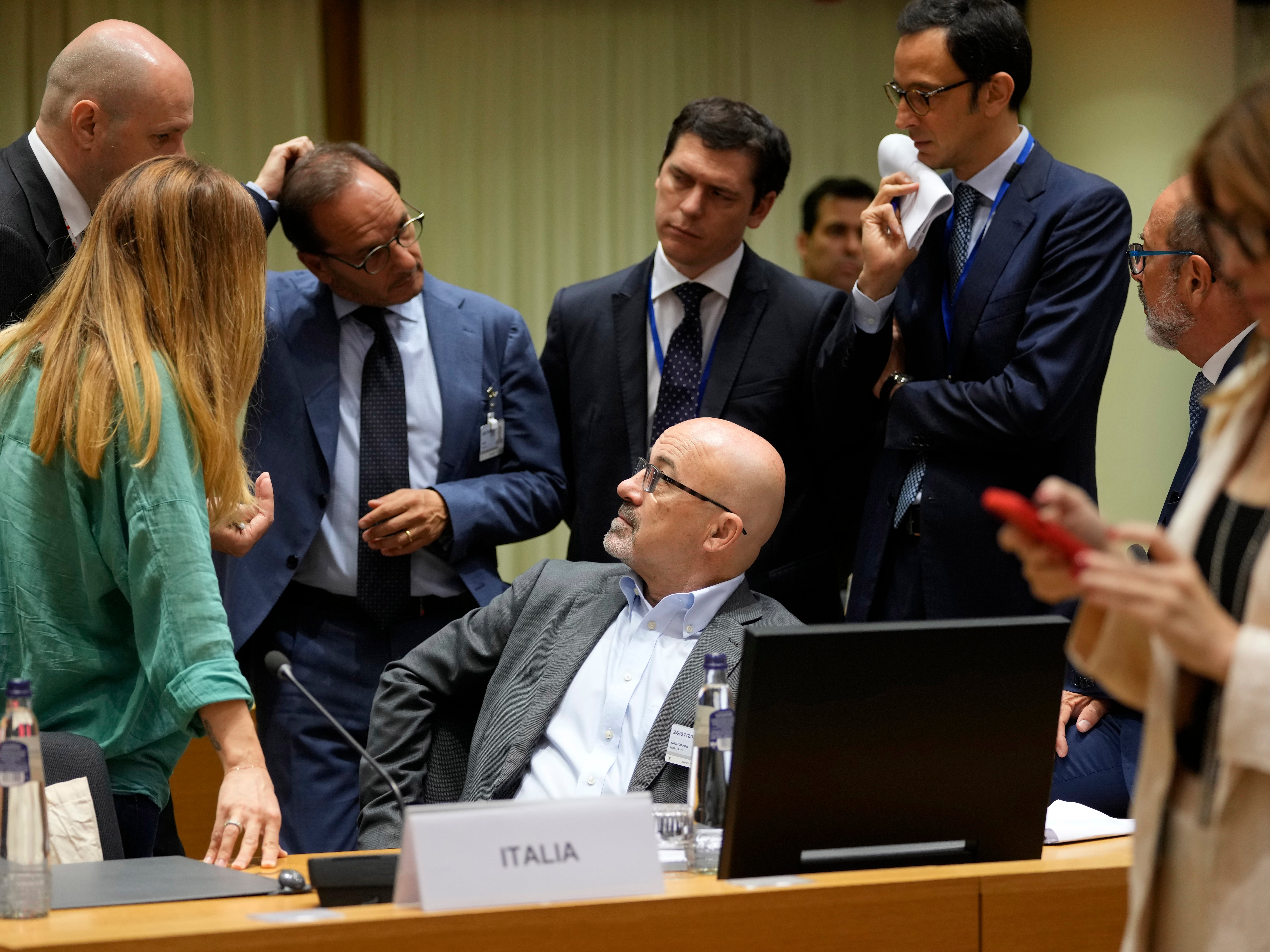 Italian energy minister Roberto Cingolani speaks with his delegation during negotiations in Brussels on Tuesday