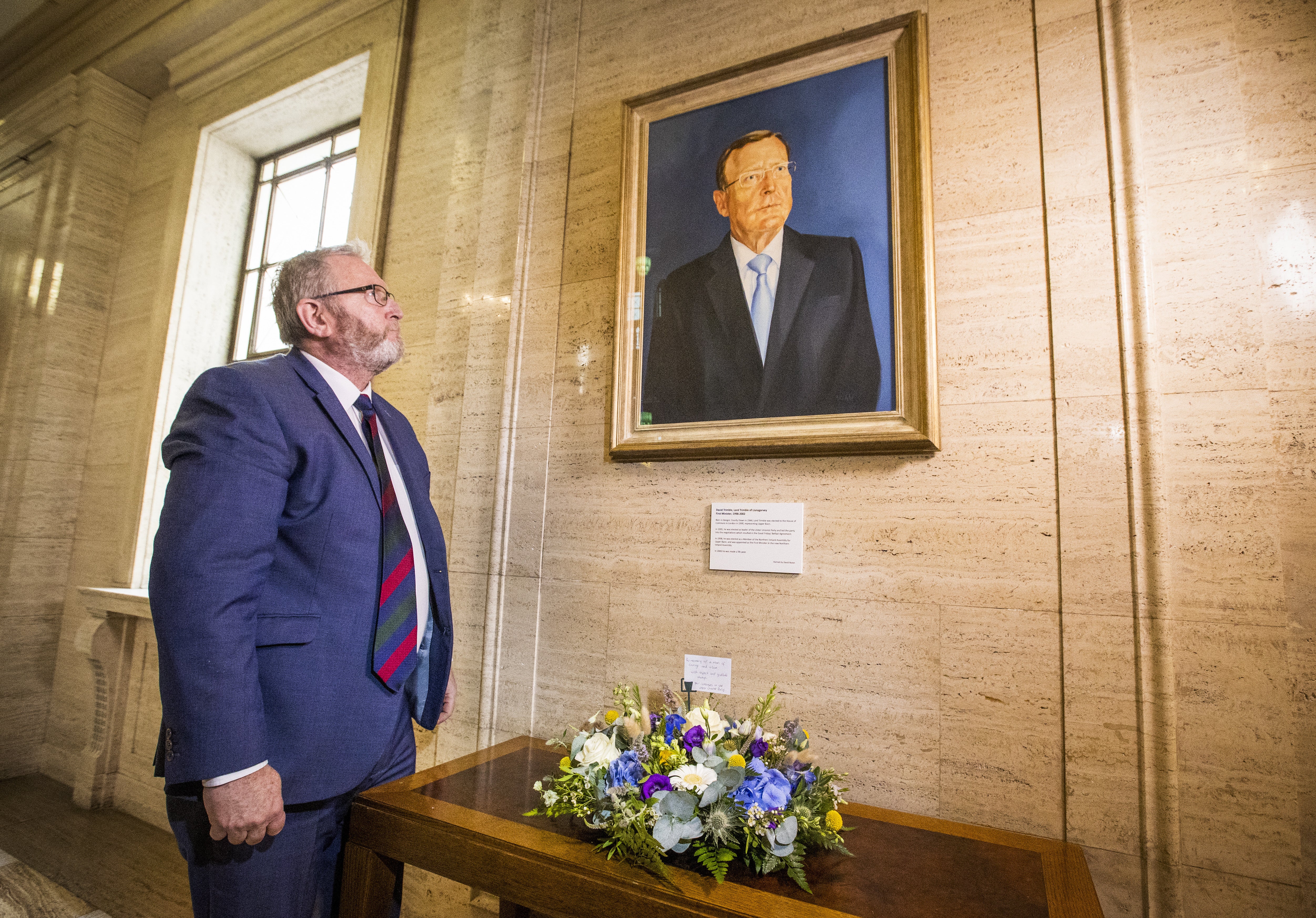 Doug Beattie, leader of the Ulster Unionist Party, lays a wreath under the portrait of the party’s former leader David Trimble, in the Great Hall of Parliament Buildings at Stormont (Liam McBurney/PA)