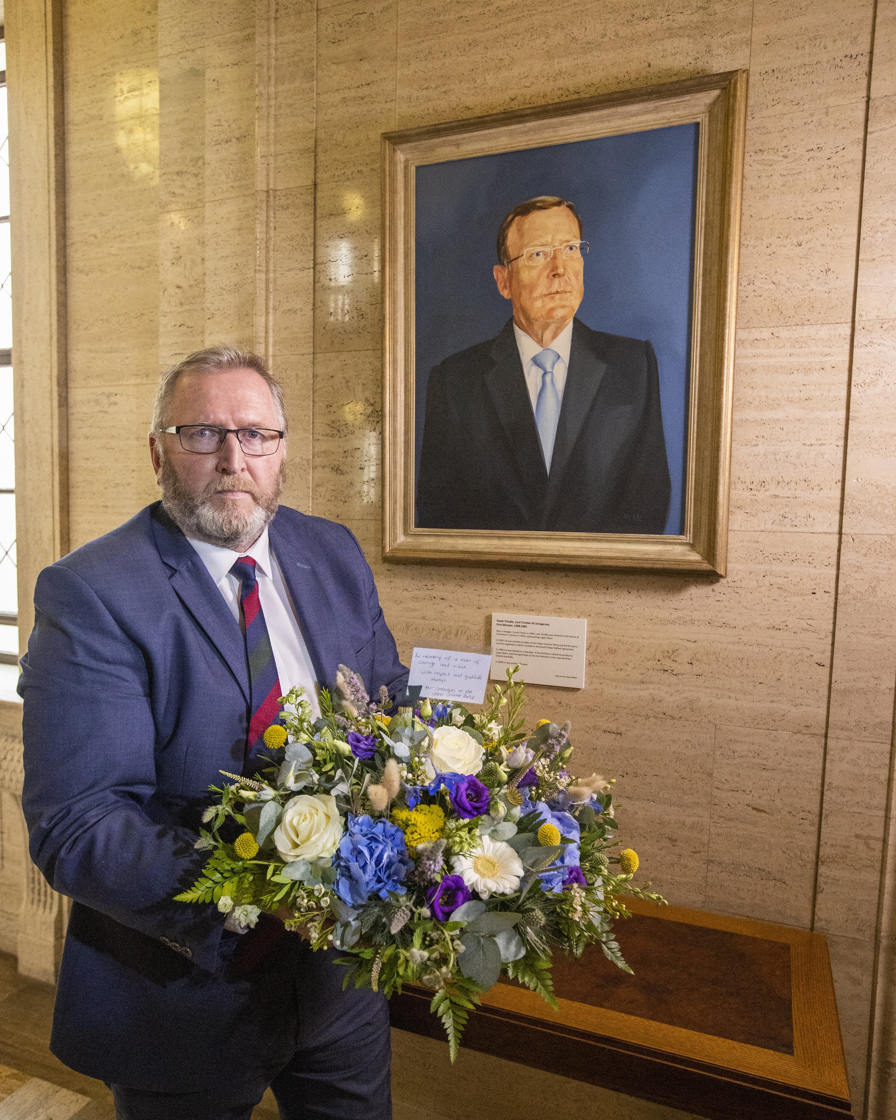 Doug Beattie, leader of the Ulster Unionist Party (UUP) lays a wreath under the portrait of the party’s former leader David Trimble, in the Great Hall of Parliament Buildings at Stormont (Liam McBurney/PA)