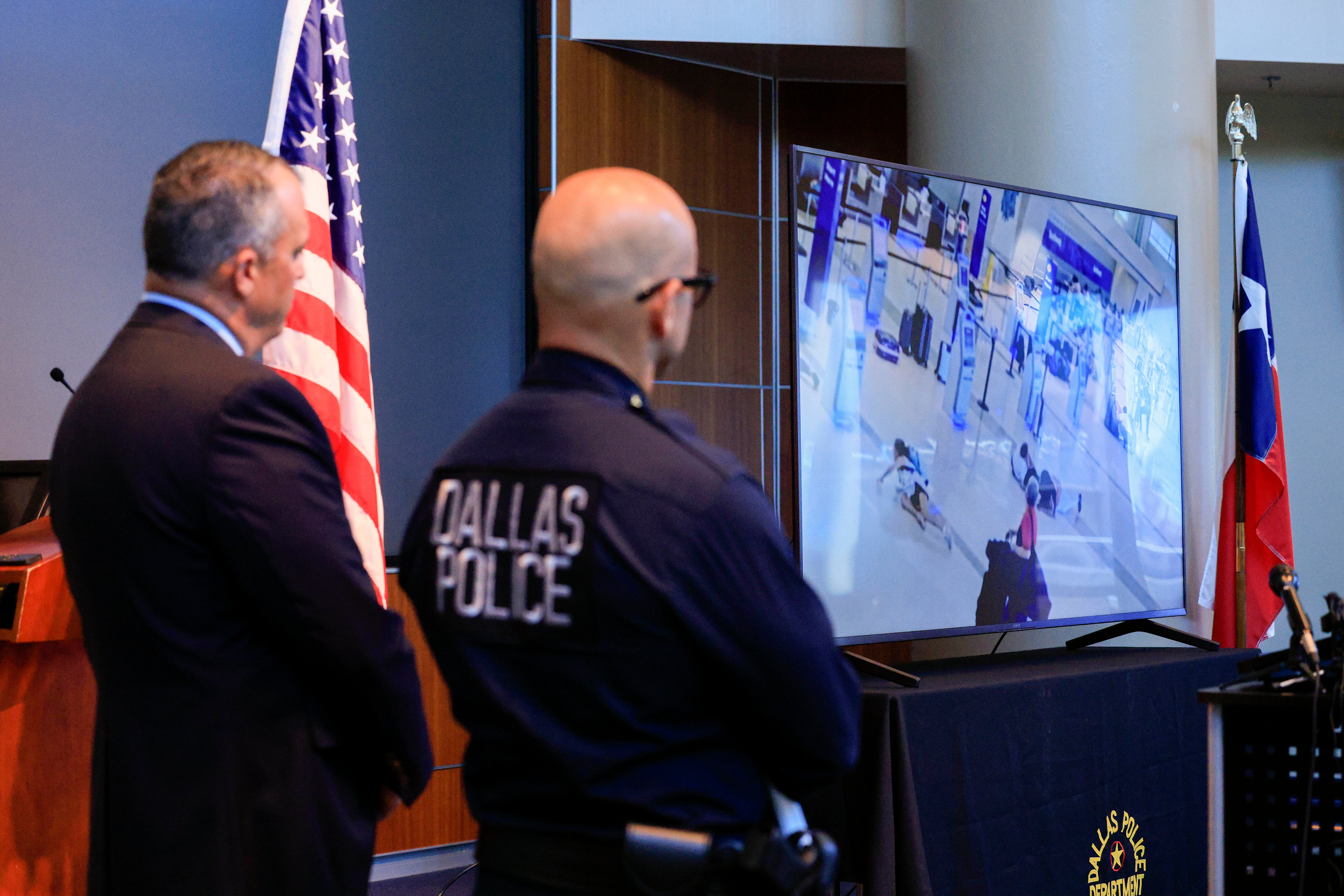 Dallas police Chief Eddie GarcÃ­a, right, and FBI Dallas Special Agent in Charge Matthew DeSarno watch surveillance footage of police officers responding to the scene of a shooting at Dallas Love Field airport during a press conference, Tuesday, 26 July 2022