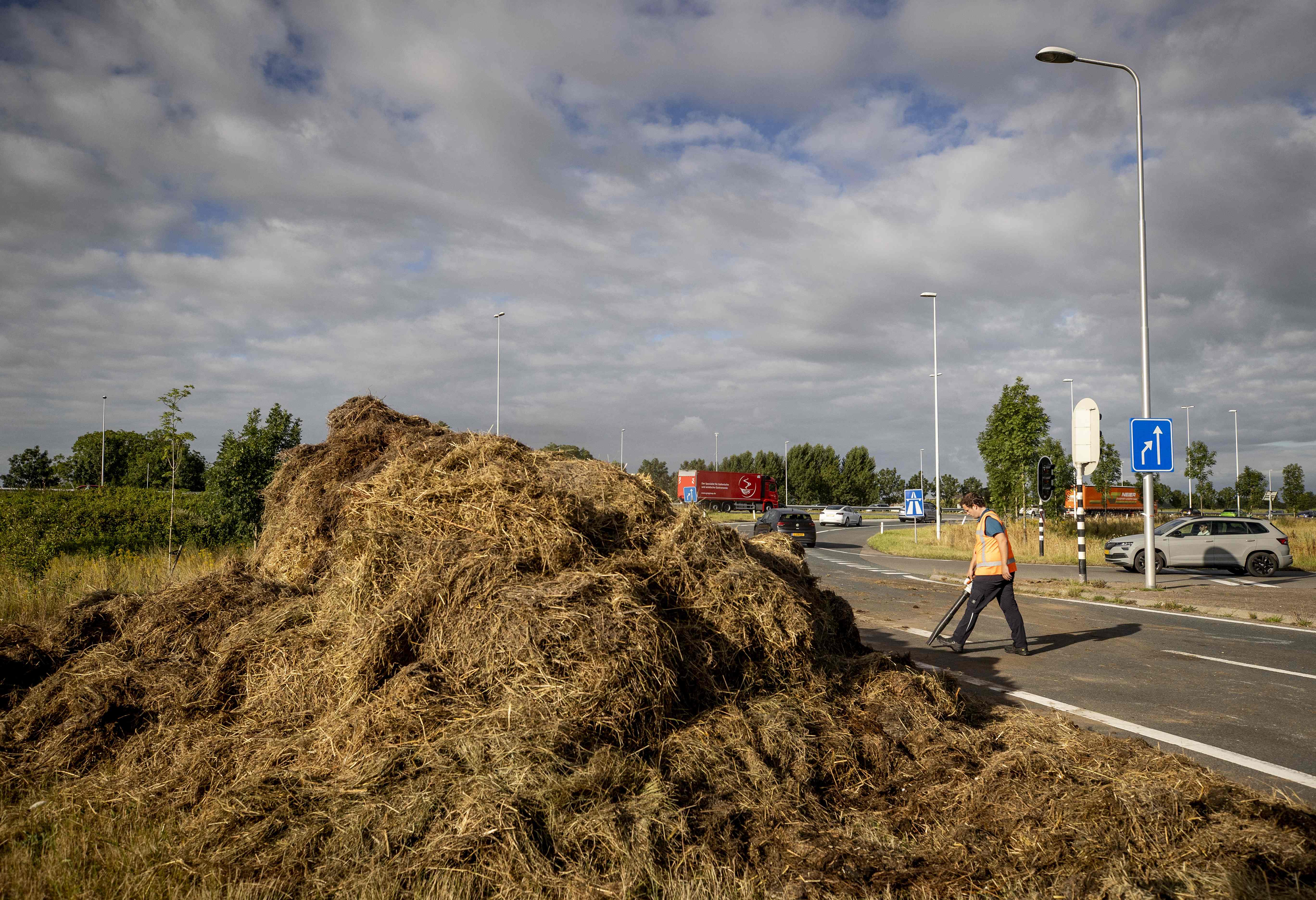 A man clears debris on a slip road of the A12 highway near Bunnik