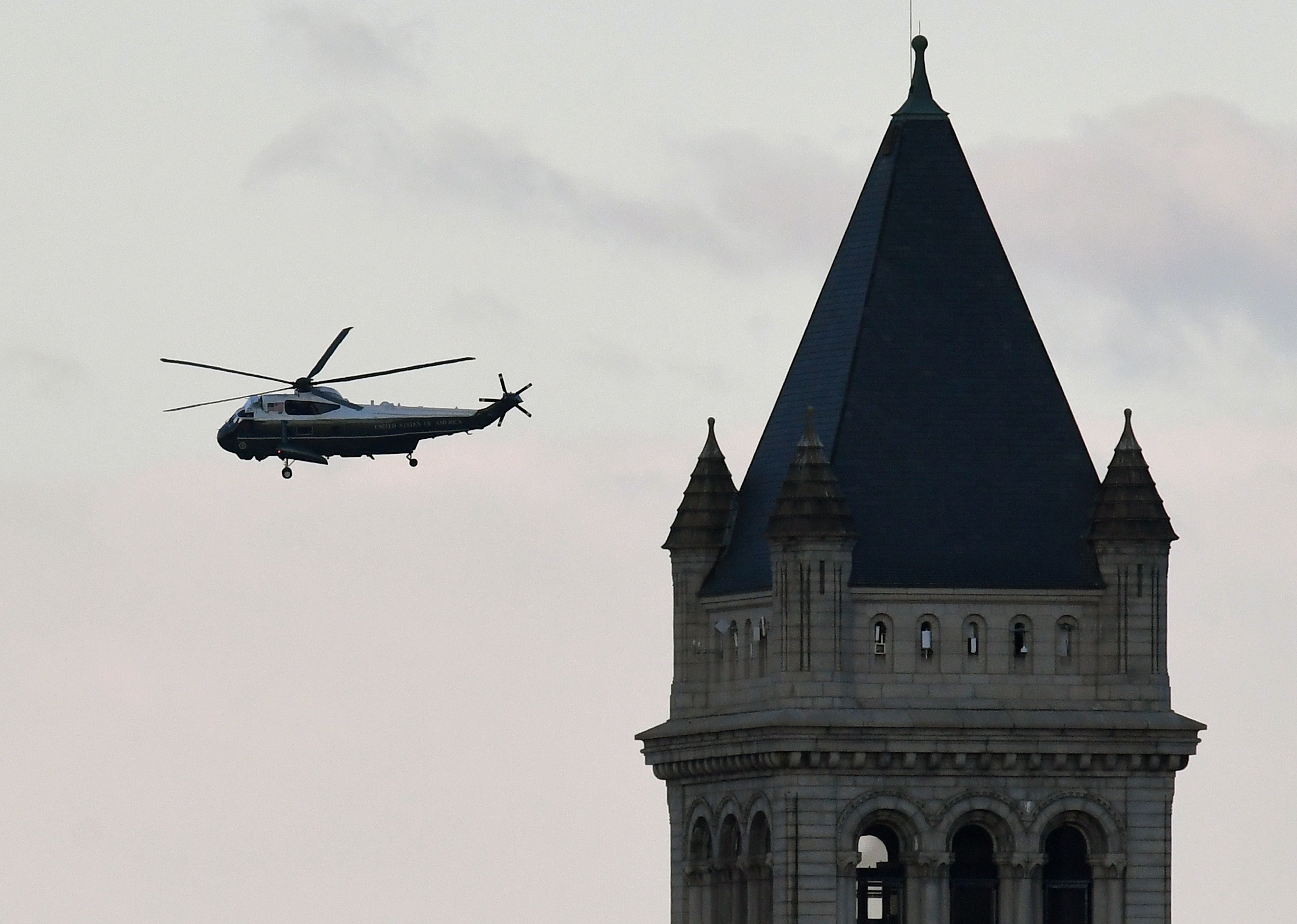 Marine One with US President Donald Trump and First Lady Melania Trump passes the Trump International Hotel (R) as it departs the White House in Washington, DC, on January 20, 2021