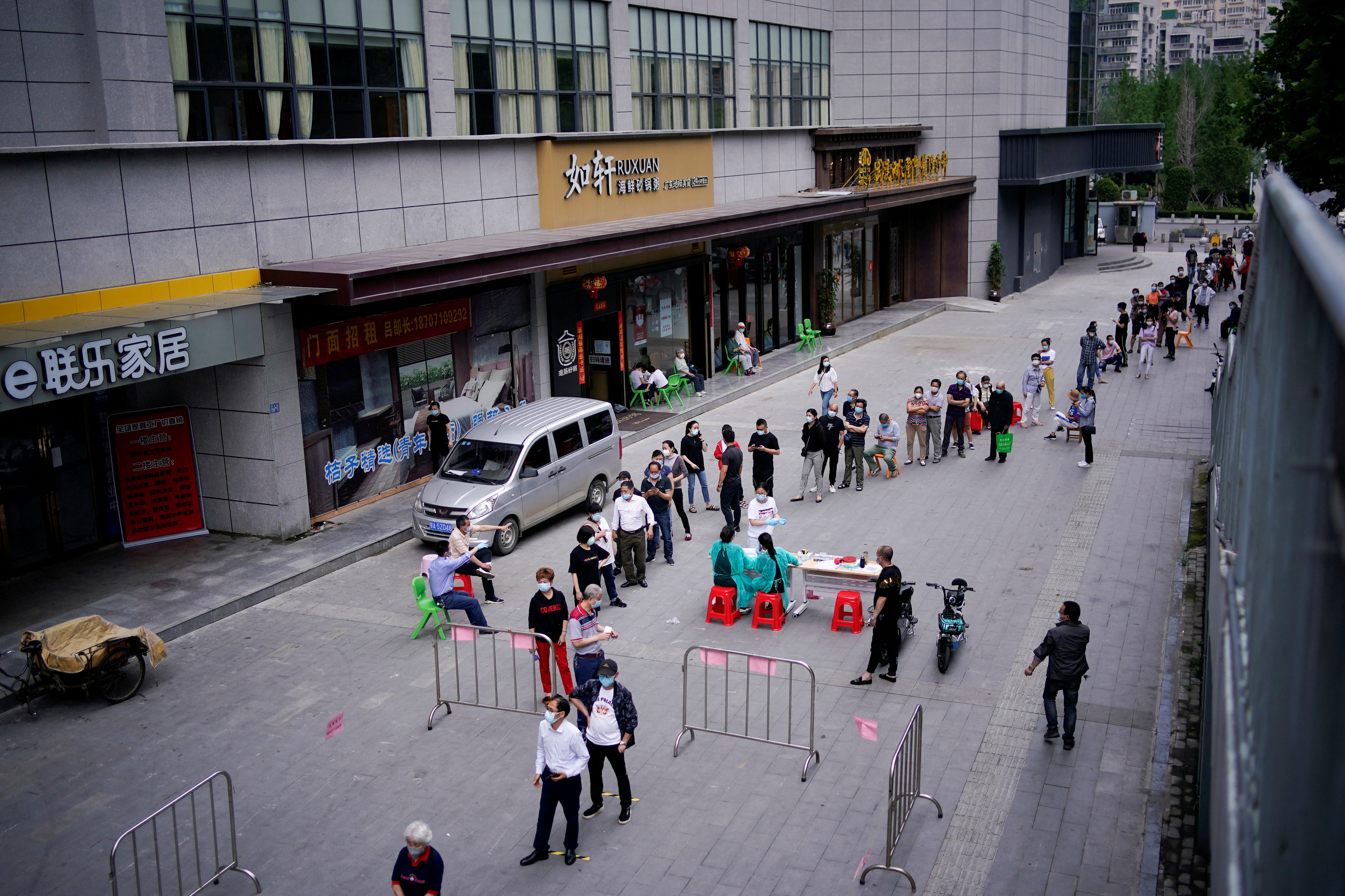 A picture from May 2020 shows residents wearing face masks queue for nucleic acid testings in Wuhan, the Chinese city hit hardest by the coronavirus disease