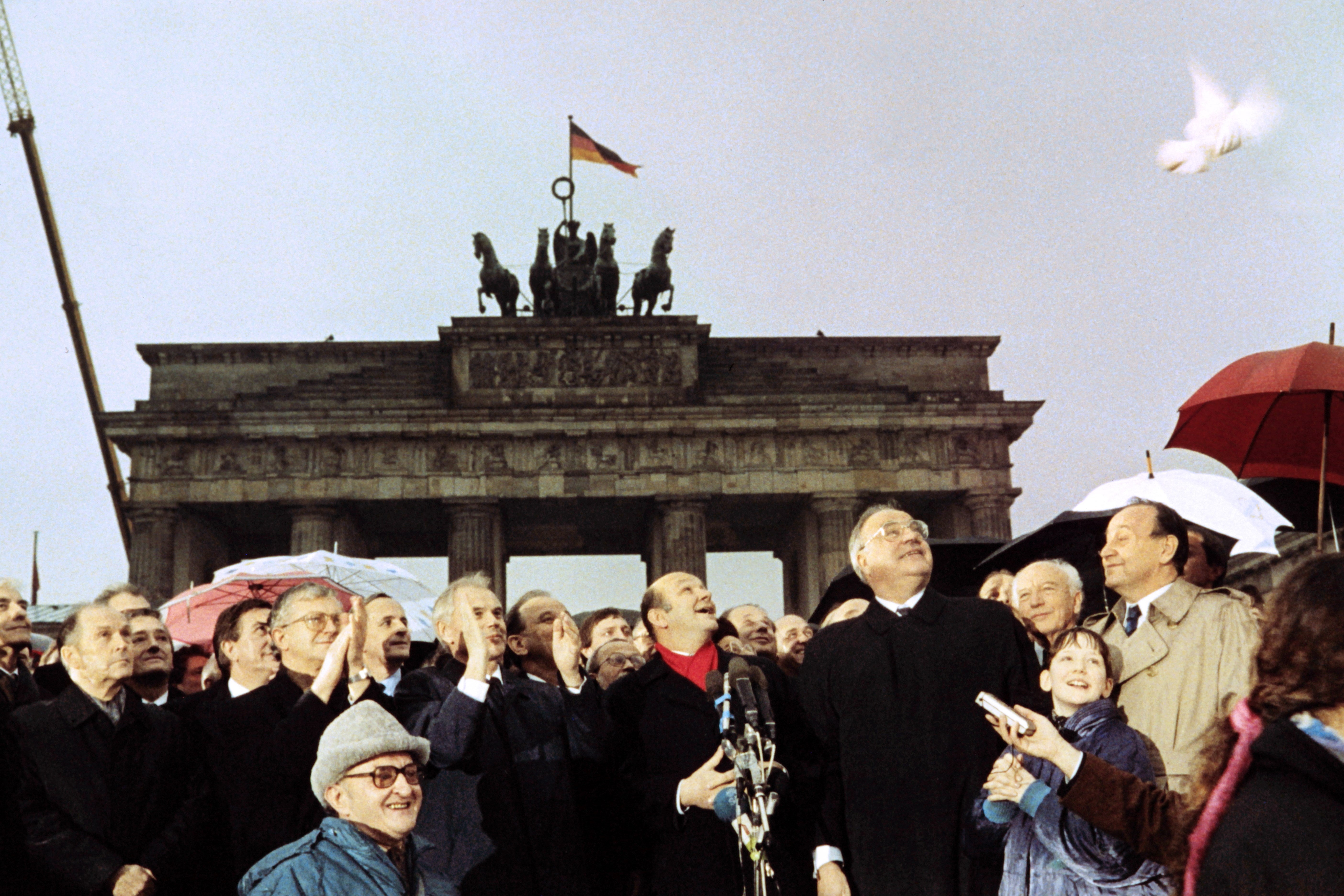 West German chancellor Helmut Kohl, East German prime minister Hans Modrow and West Berlin mayor Walter Momper wave to the crowd, 1989