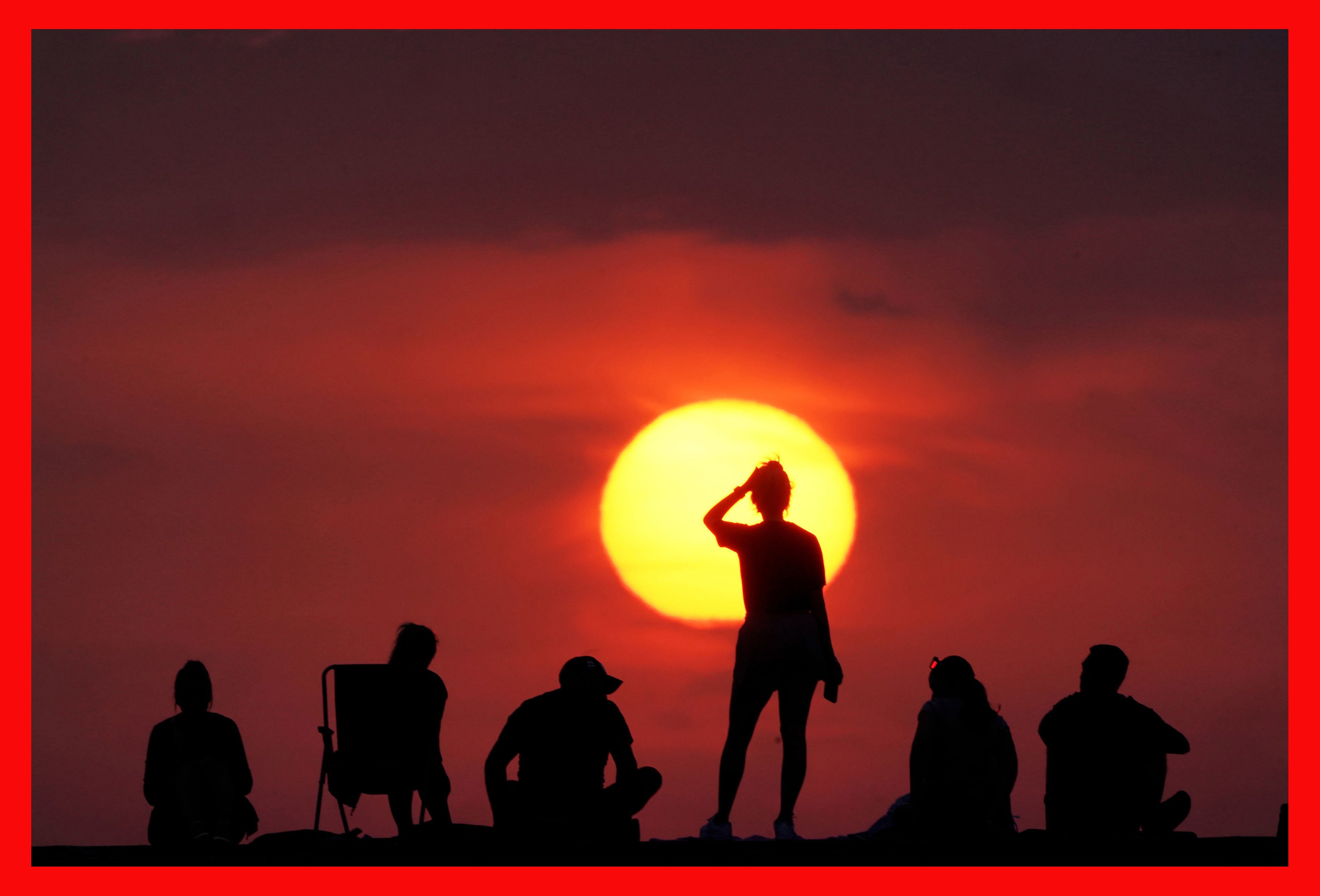 People turn out to watch the sunrise at Cullercoats Bay, North Tyneside.