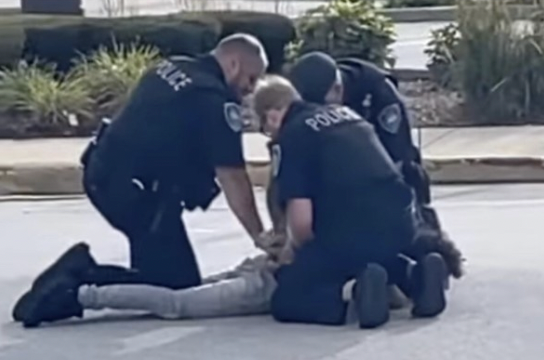 Officers from the Oak Lawn police department kneel on a teen suspect