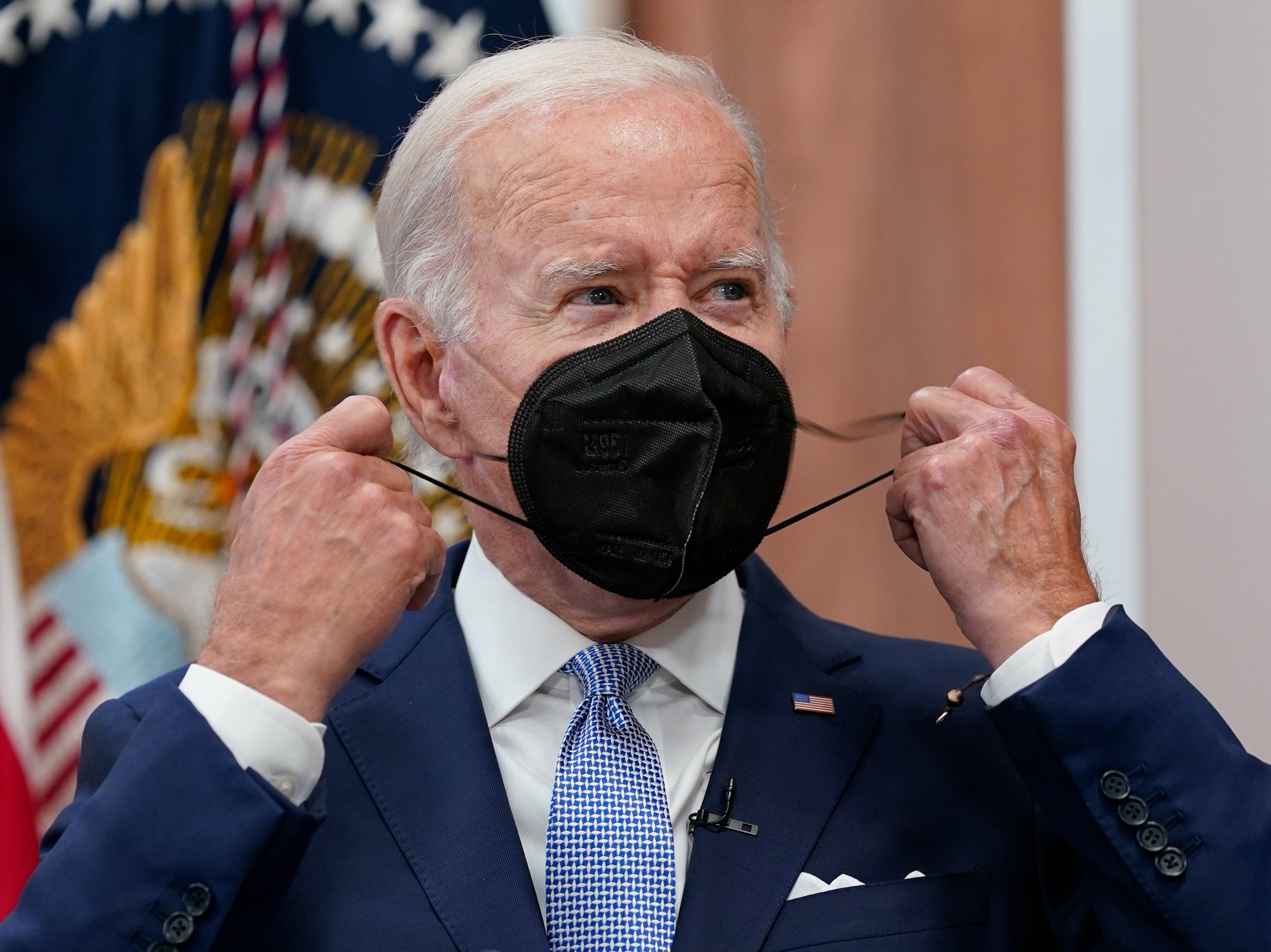 President Joe Biden removes his face mask as he arrives to speak about the economy during a meeting with CEOs in the South Court Auditorium on the White House complex in Washington, Thursday, July 28, 2022