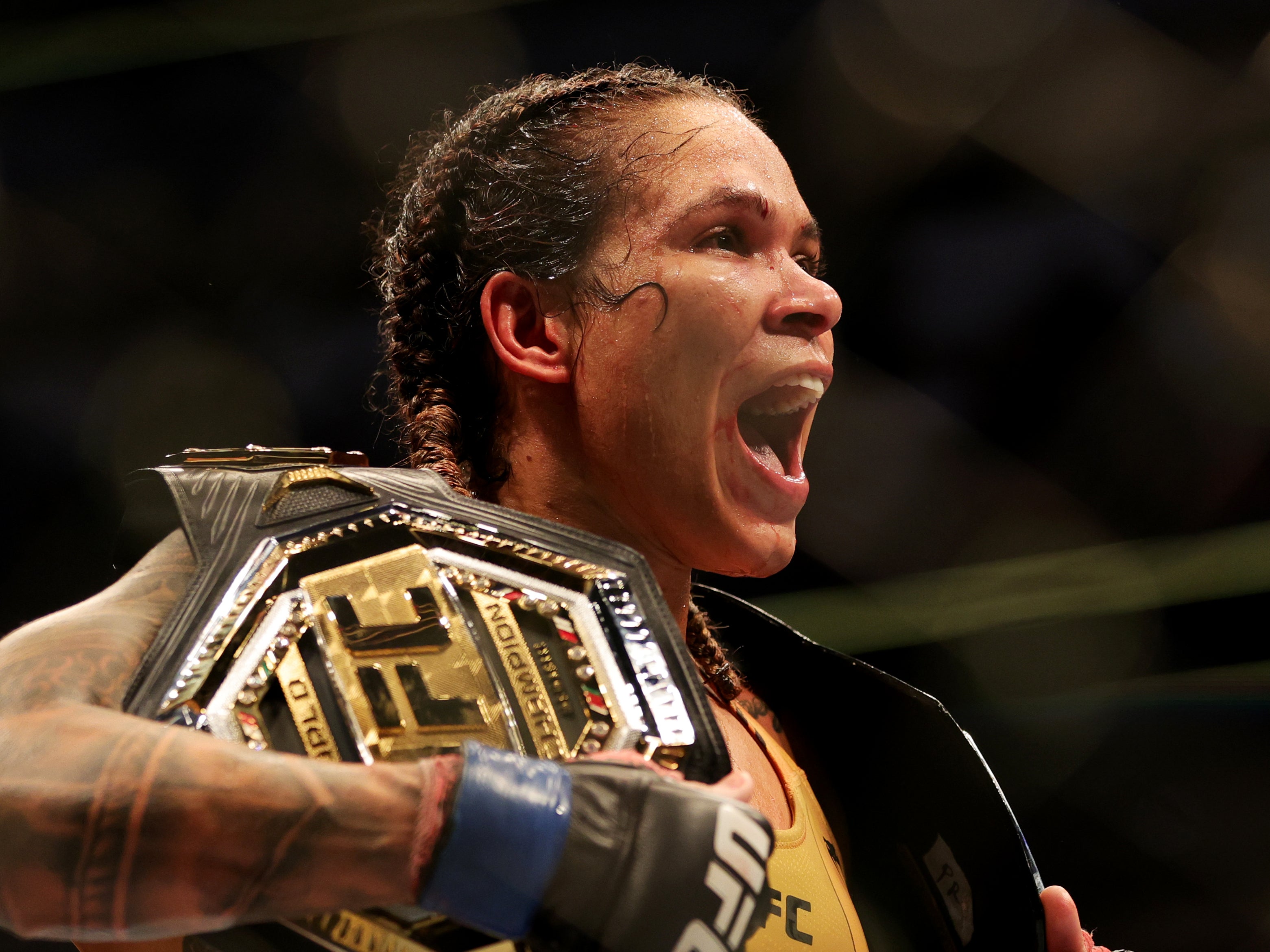 Amanda Nunes with the UFC women’s bantamweight and featherweight titles