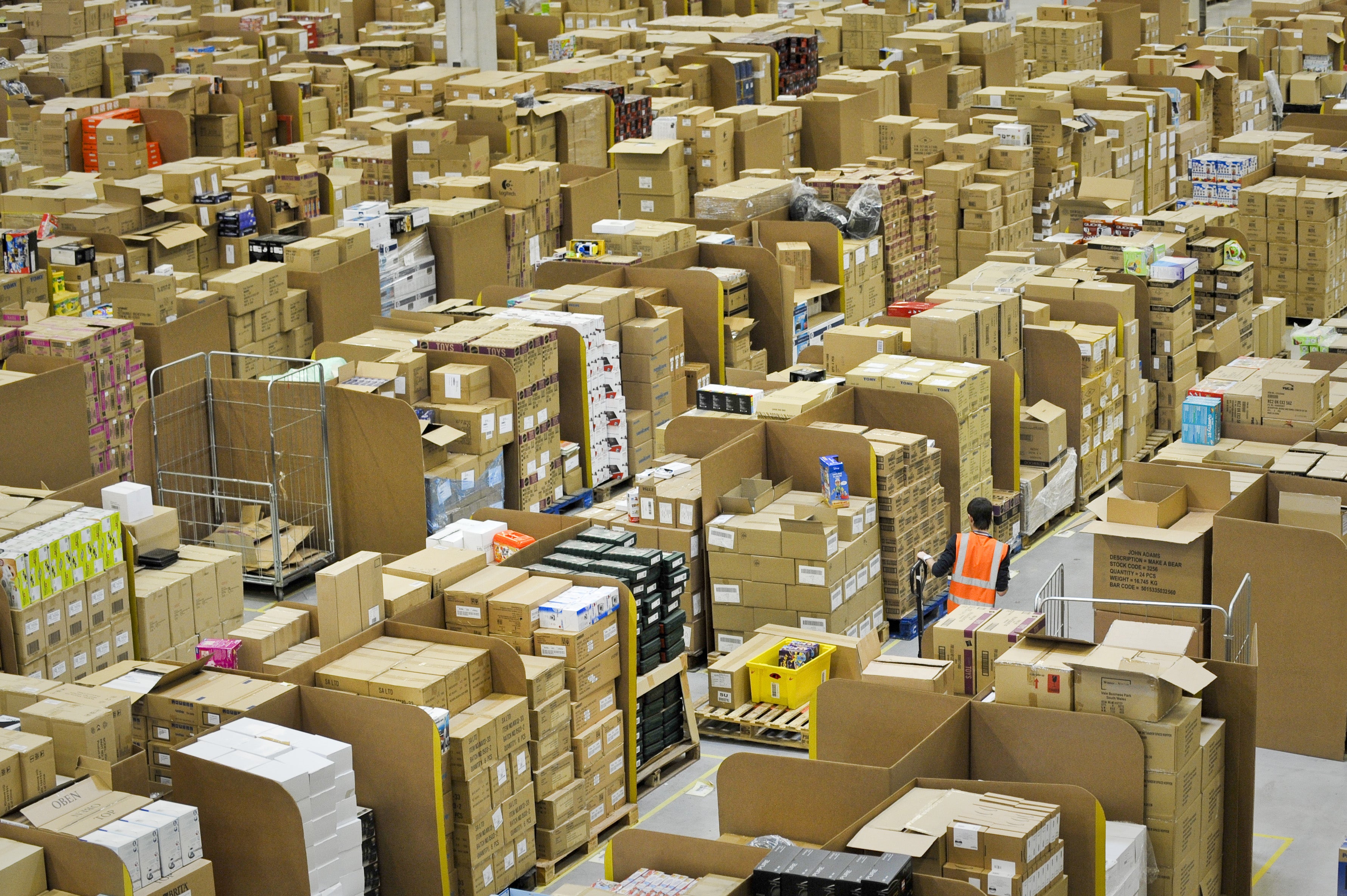 A worker pushing a pallet truck among boxes at a distribution centre (Ben Birchall/PA)