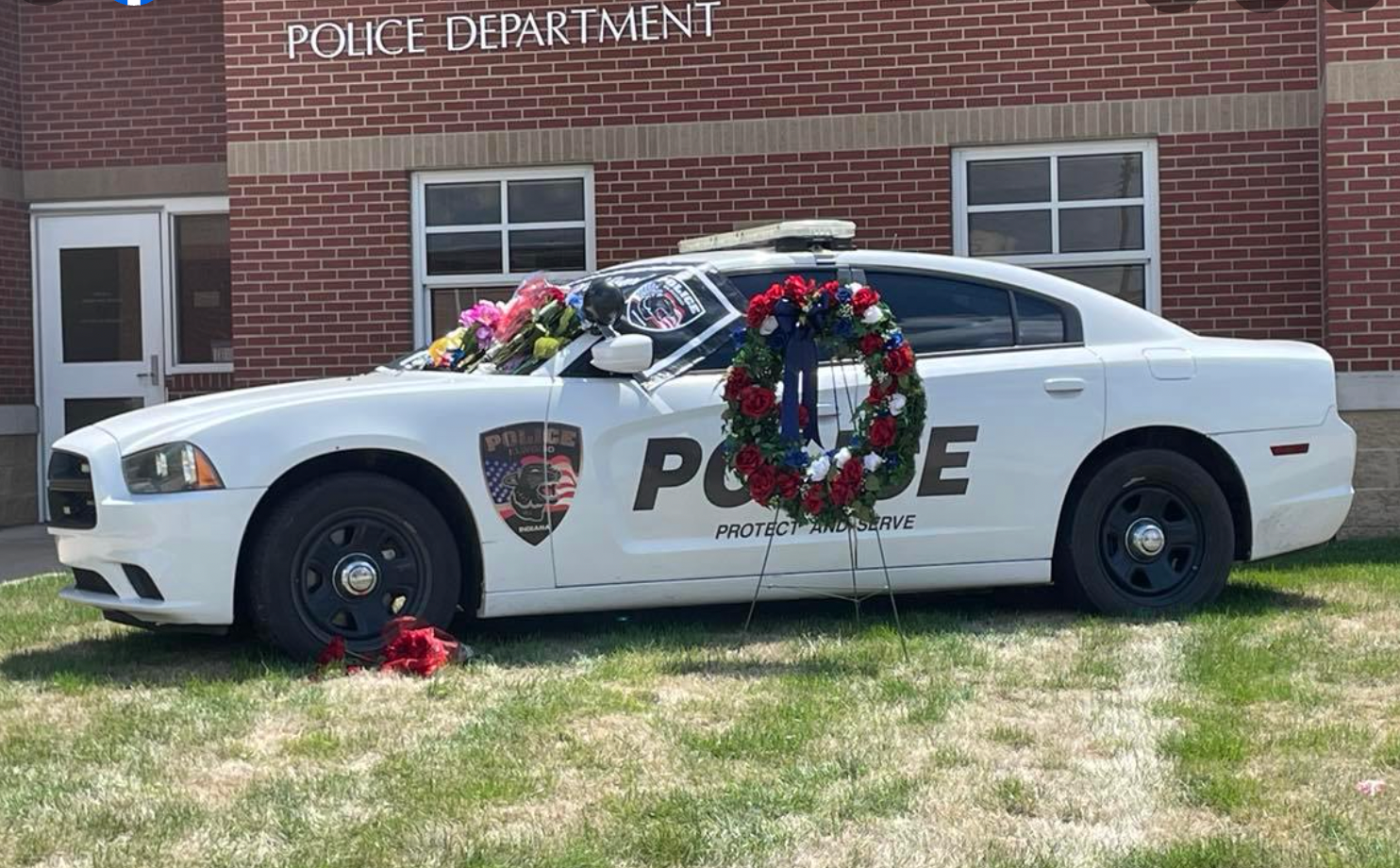 Outside the Elwood Police Department precinct, Officer Shahnavaz’s patrol has been turned into a memorial where members of the communities have left flowers and American flags