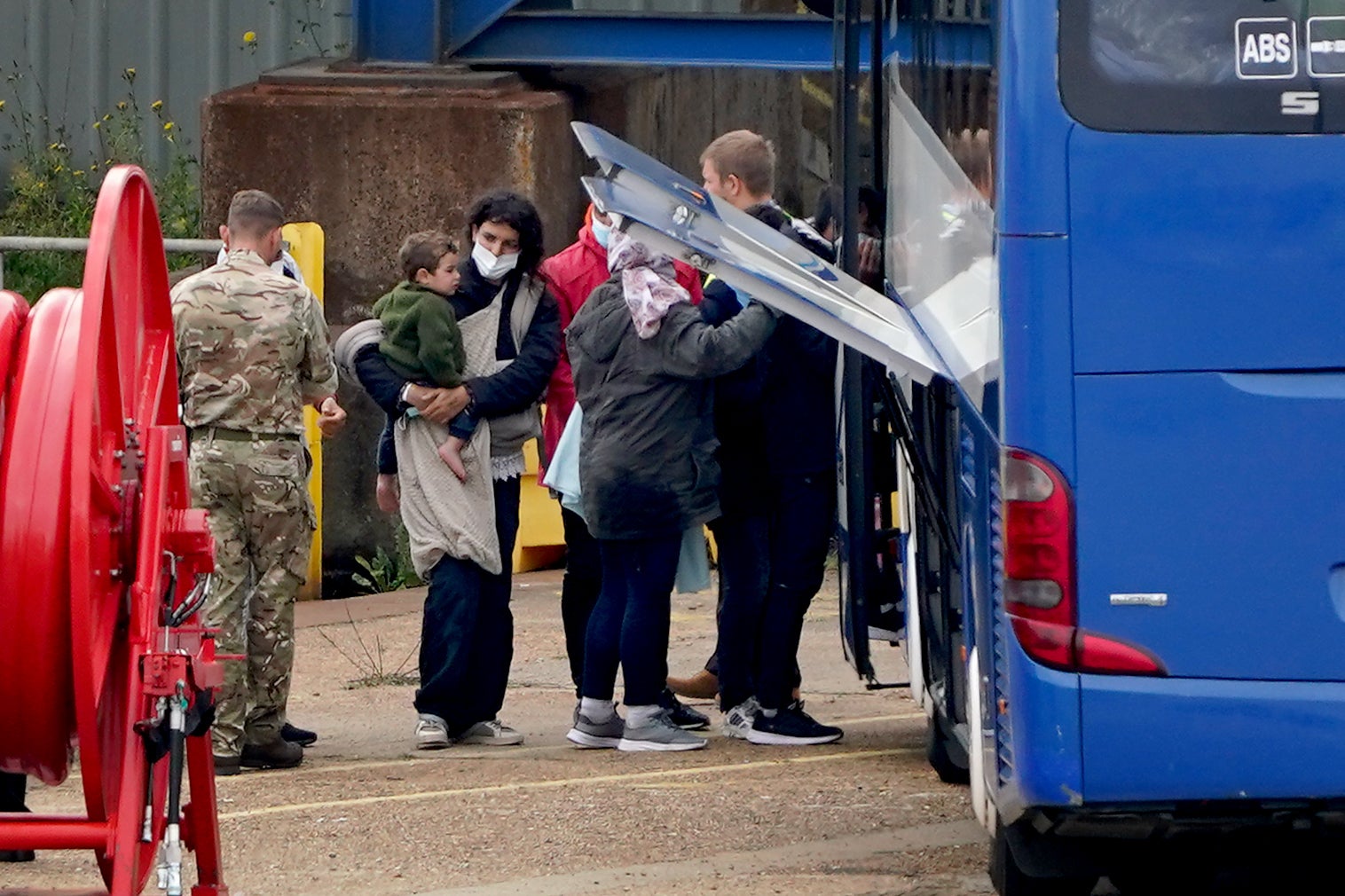 A woman and child board a bus after beigh brought to the shore in Ramsgate