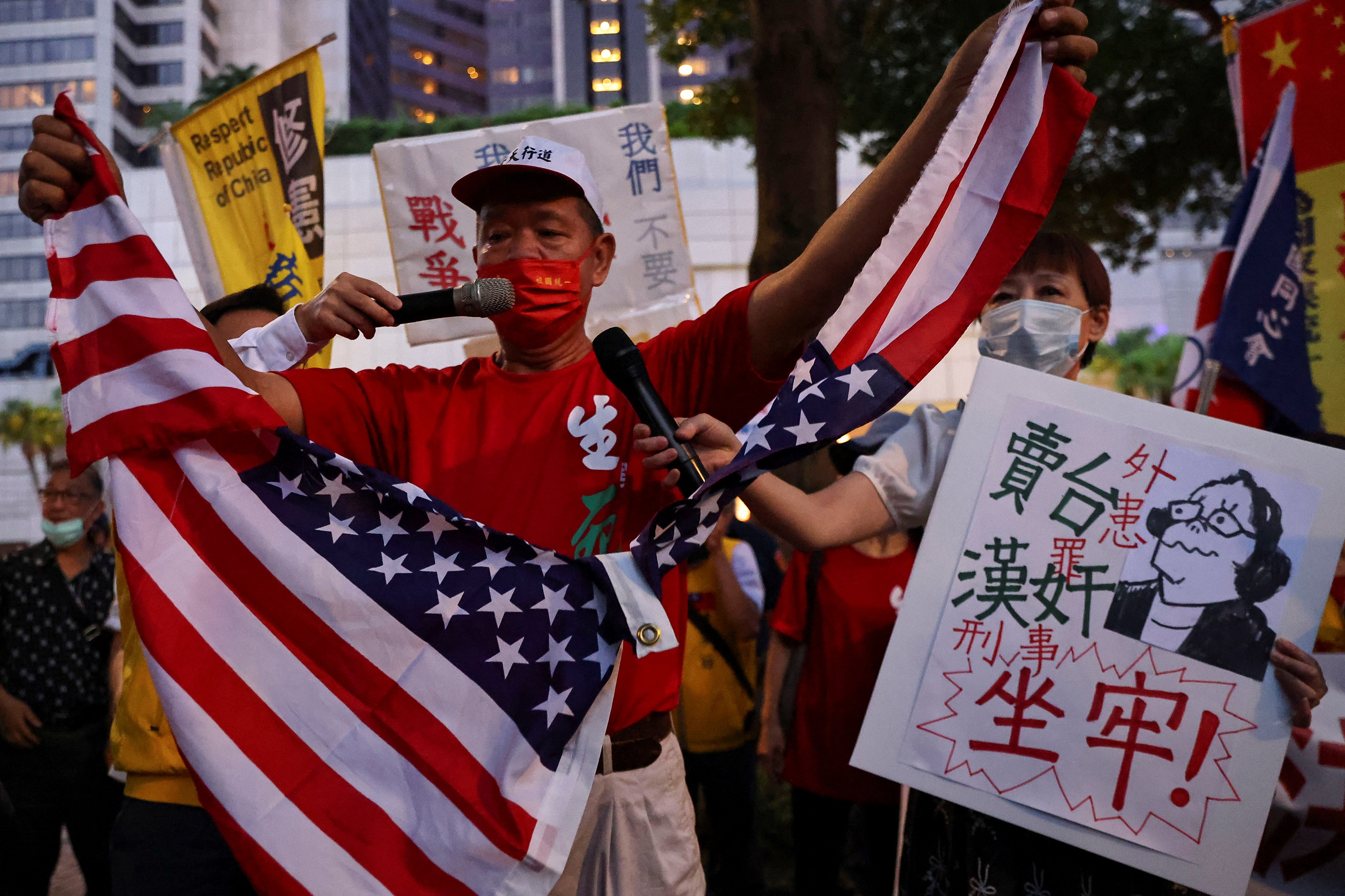 A demonstrator rips up a US flag during a protest