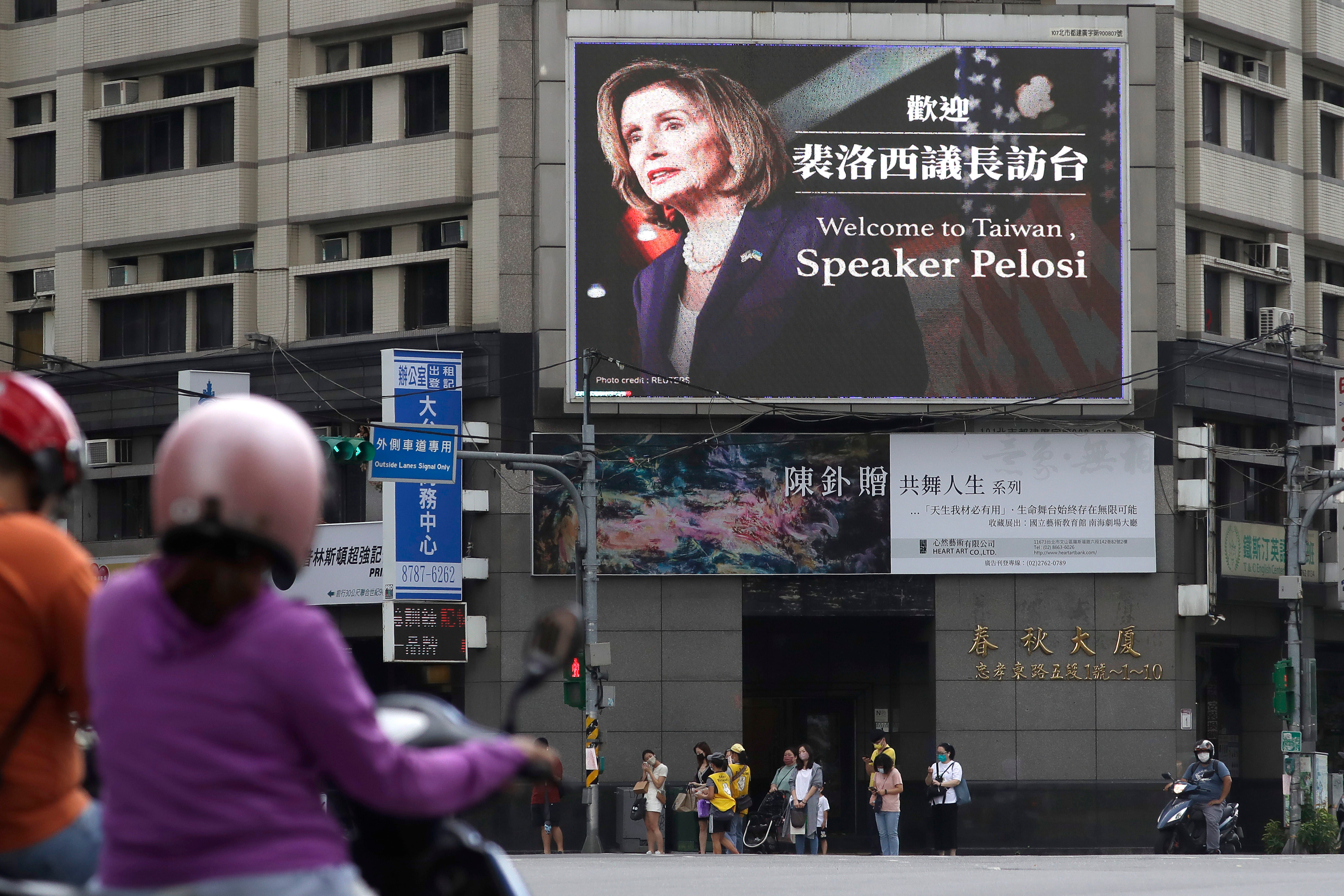 People walk past a billboard welcoming US House Speaker Nancy Pelosi, in Taipei, Taiwan on 3 August