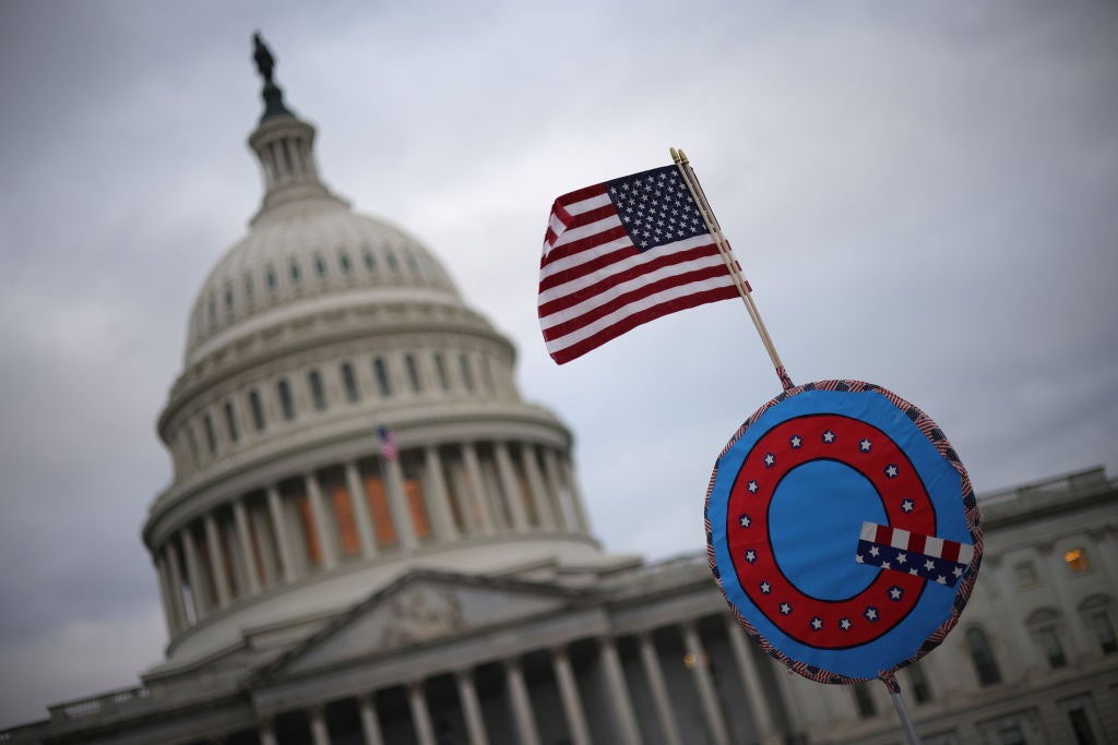 A protester holds a QAnon symbol aloft outside the US Capitol