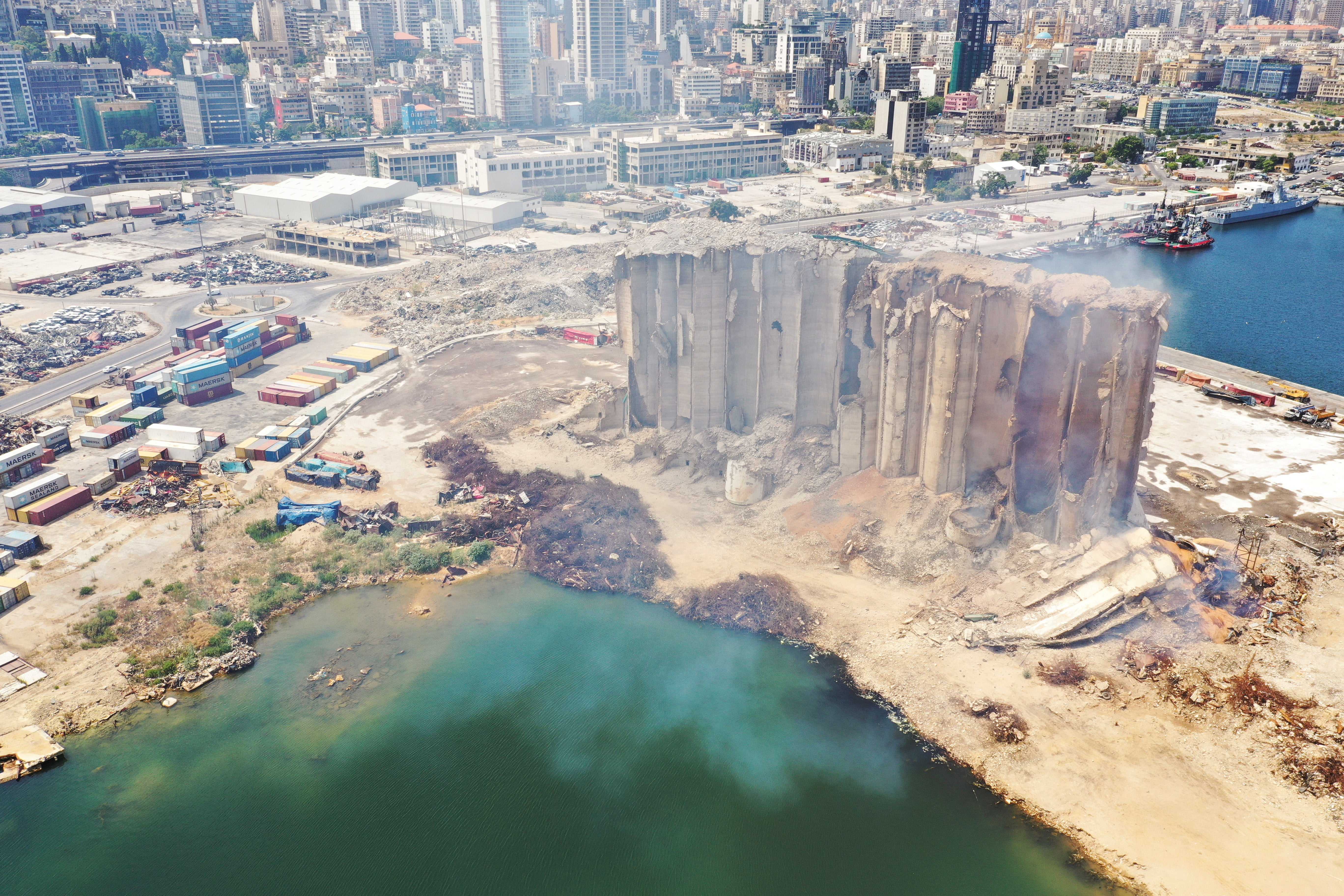 Smoke rises from the partially-collapsed Beirut grain silos, damaged in the August 2020 port blast