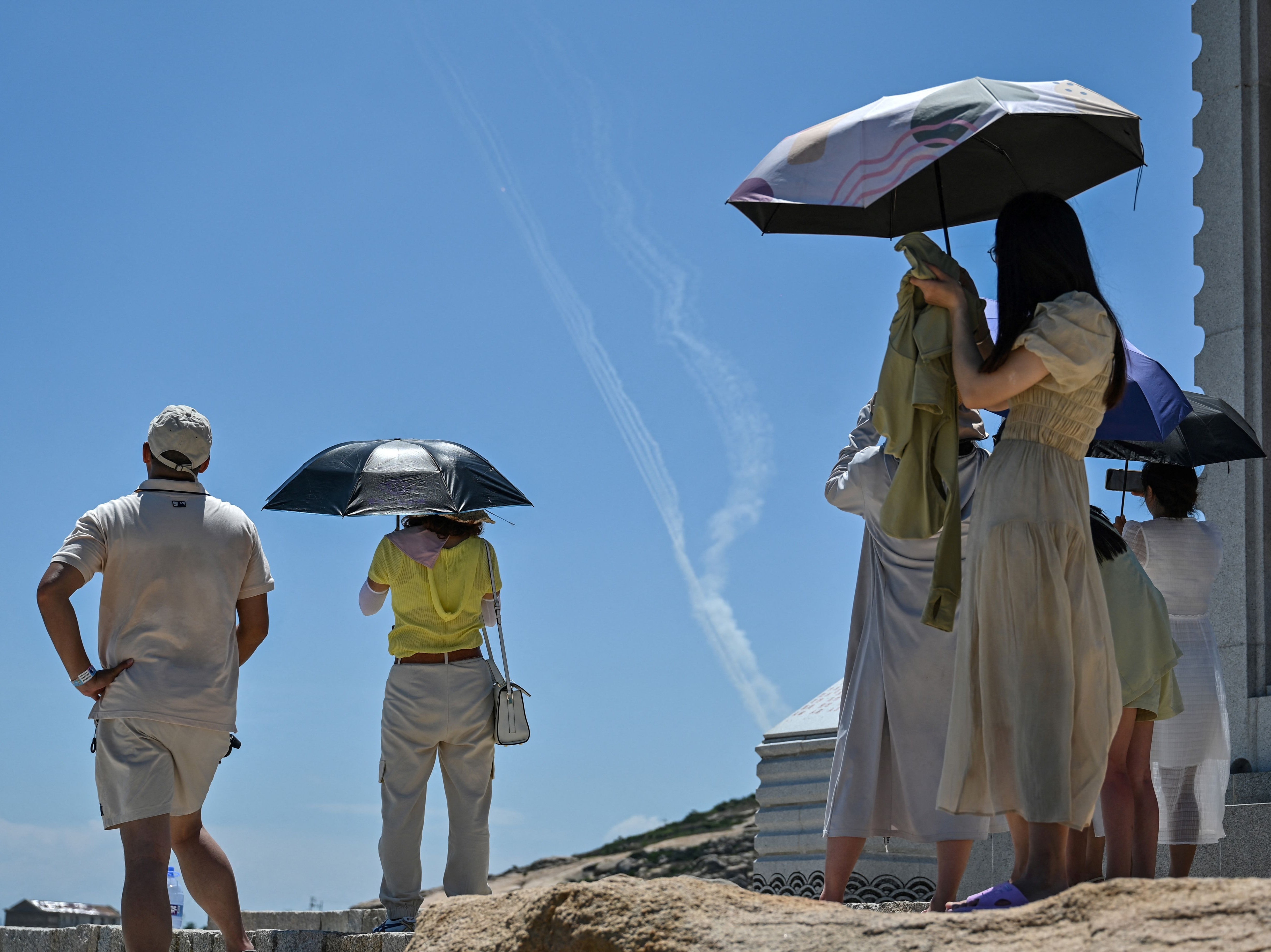 Smoke trails from projectiles launched by the Chinese military are watched by tourists looking on from Pingtan island, one of mainland China’s closest points to Taiwan