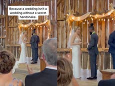 Bride and groom surprise wedding guests with secret handshake at the altar