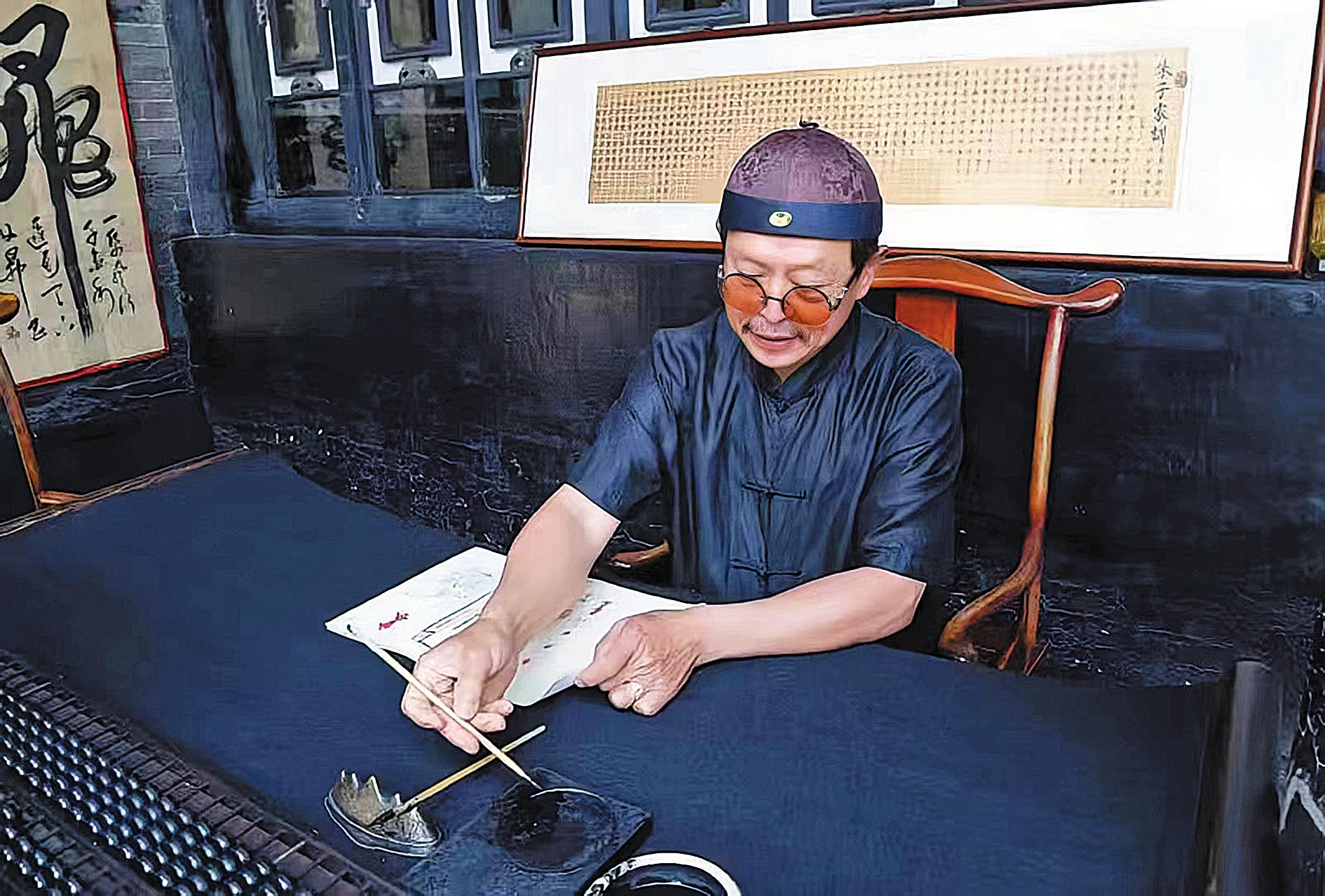 Museum guide Jia Weixing, in traditional costume, writes ‘bank drafts’ for visitors to show them how banking was done in the past