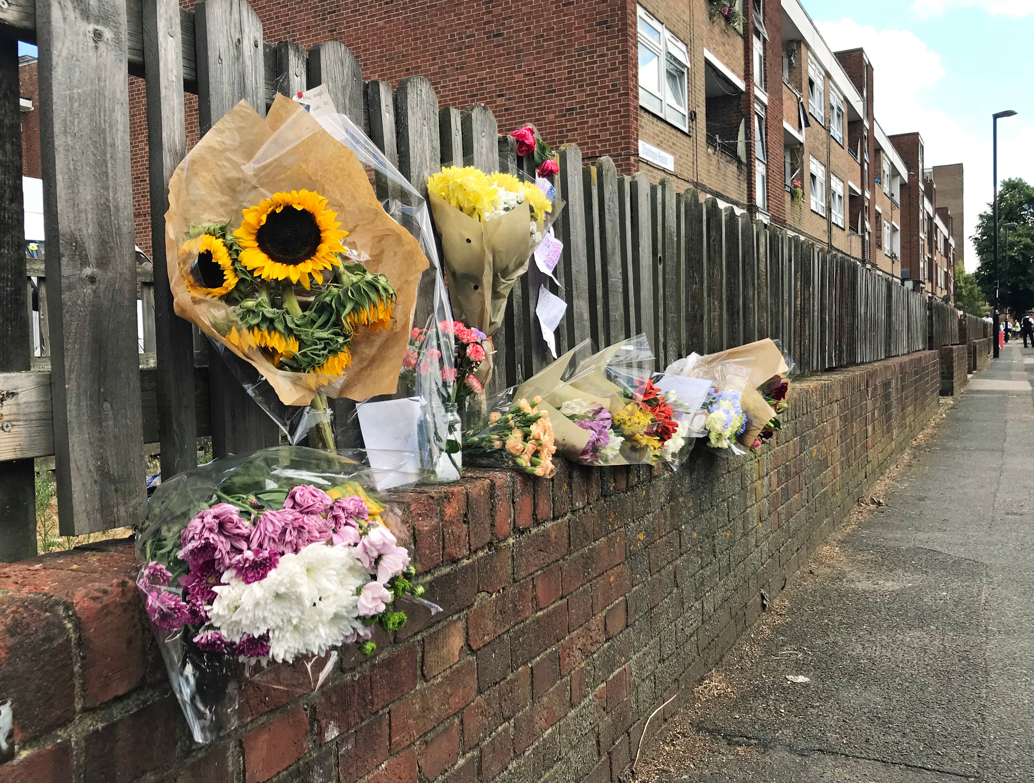 Floral tributes left on a fence near to the scene on Adolphus Street, Deptford, south-east London, where seven-year-old Joel Urhie was found dead after a blaze at his family home (Henry Vaughan/PA)