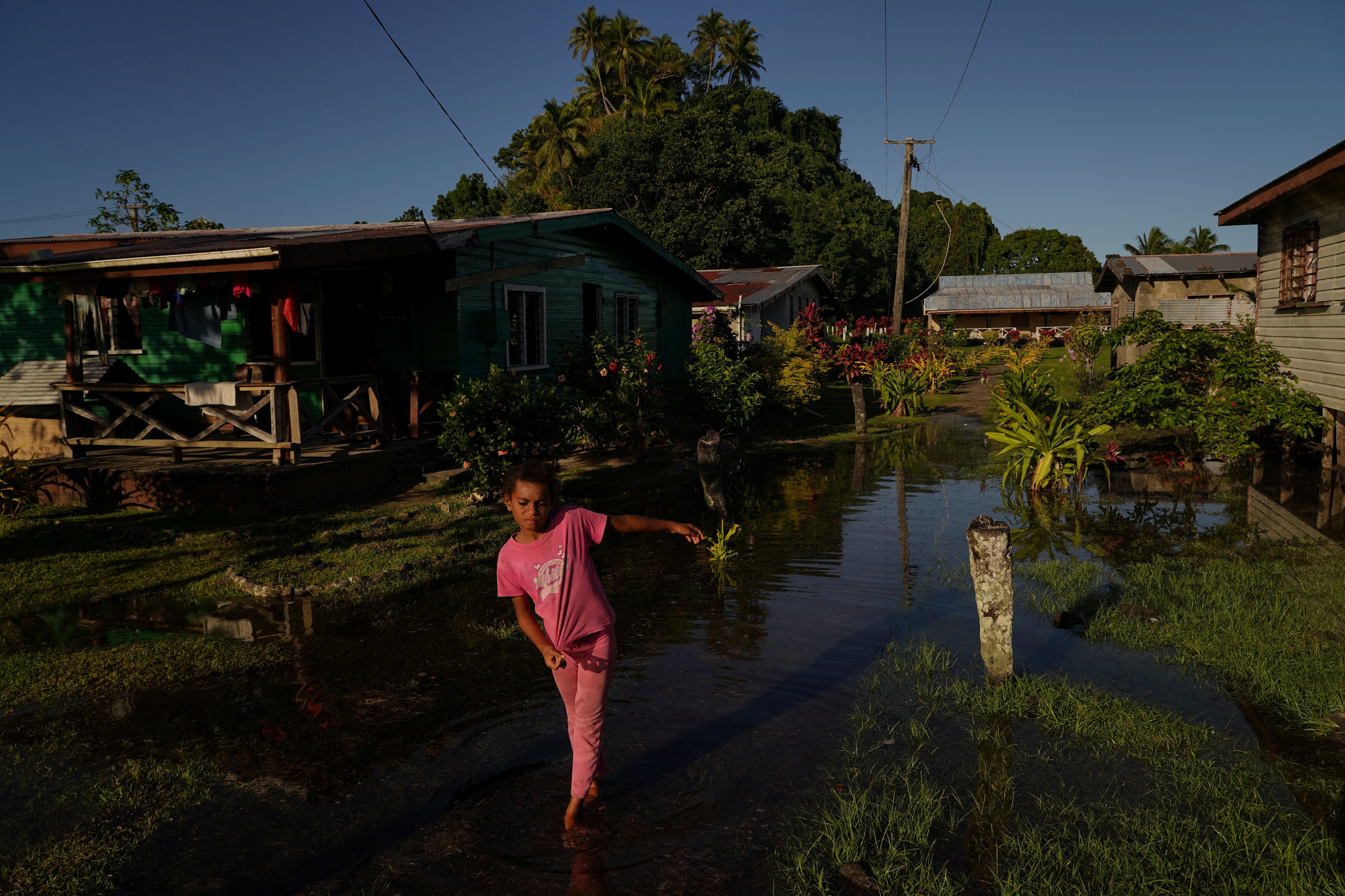 Local girl Tokasa Robanakadavu, 10, wades through seawater flooding her community during high tide in Serua village