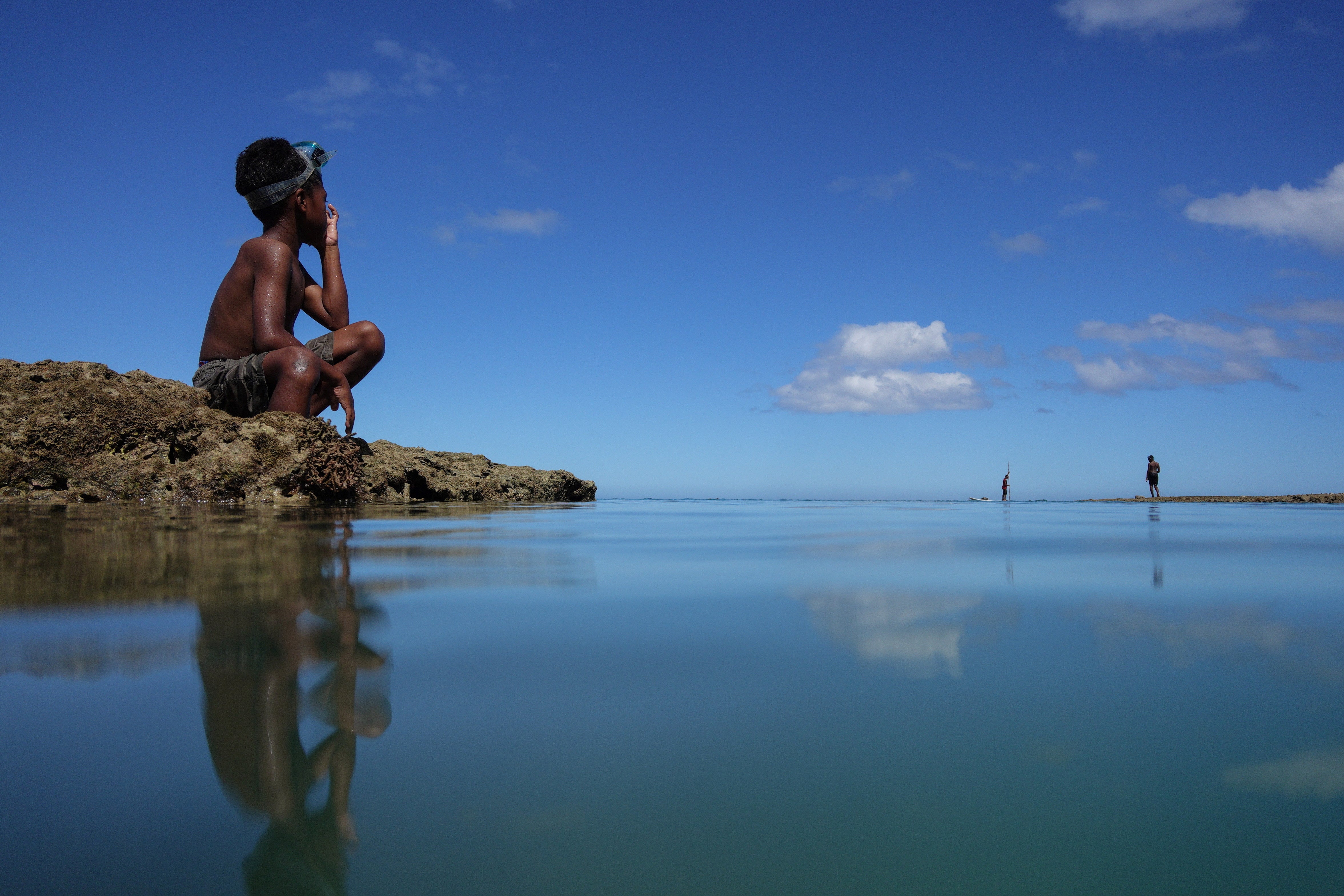 Local boy Ratukali Madanawa, 8, takes a break from diving in the sea at Serua village