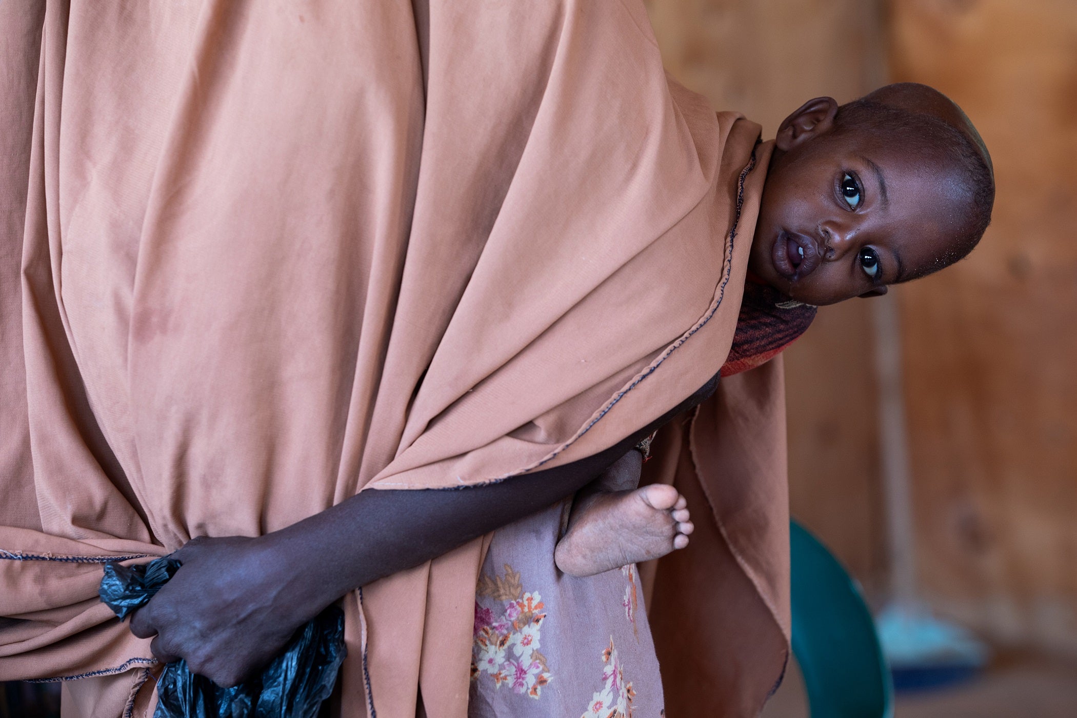 Baby Abdi is held by his mother Ambiyo at the Kabasa health centre