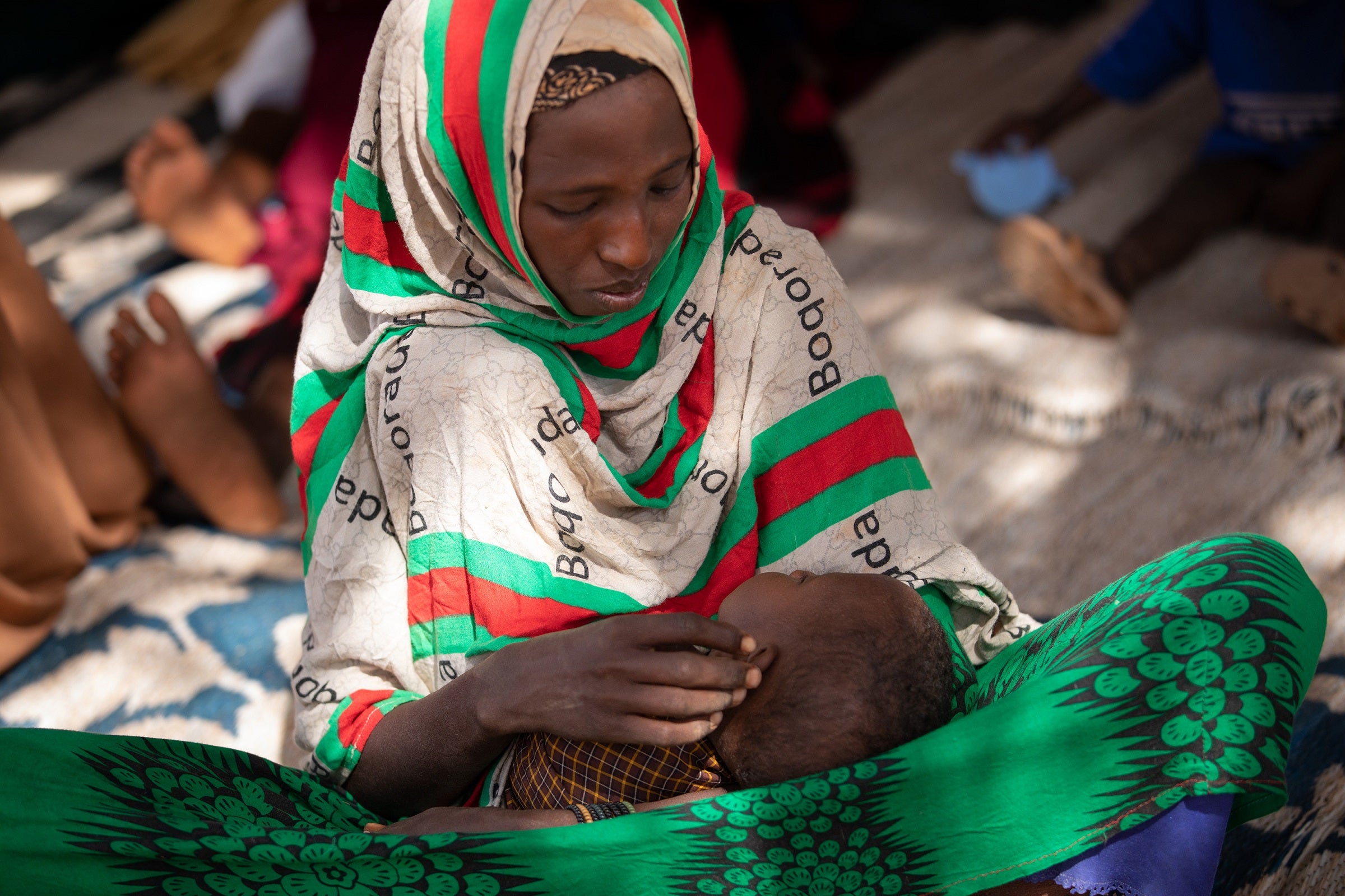 Mido holds her daughter Fatun in the waiting area of the clinic