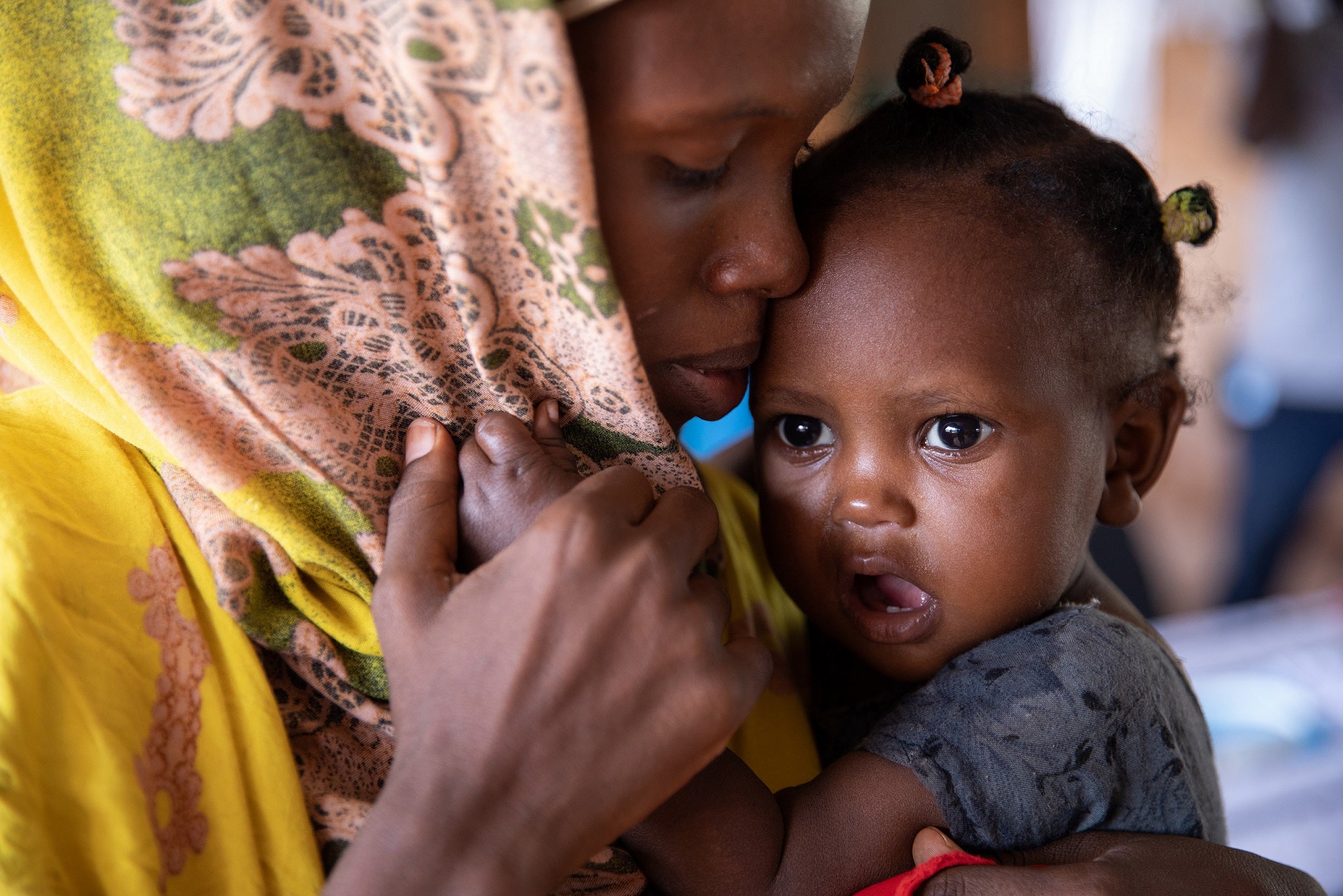 Baby Mushtaq is comforted by her mother Ayan at the WFP-funded Kabasa health centre. She is there to have her MUAC measured, as well as her height and weight recorded in order to assess her malnutrition status