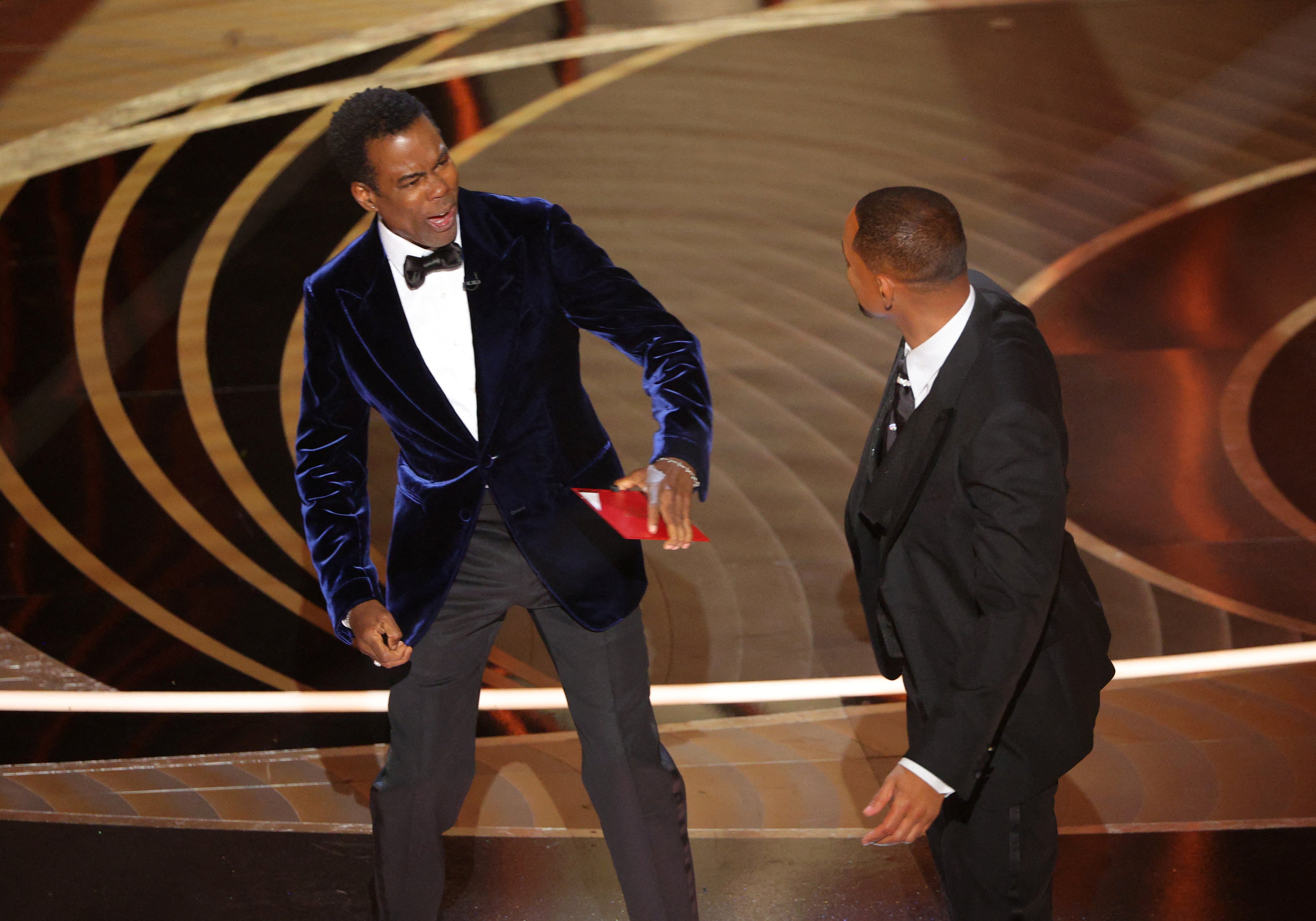 Chris Rock reacts after being hit by Will Smith as he spoke on stage during the 94th Academy Awards in Hollywood