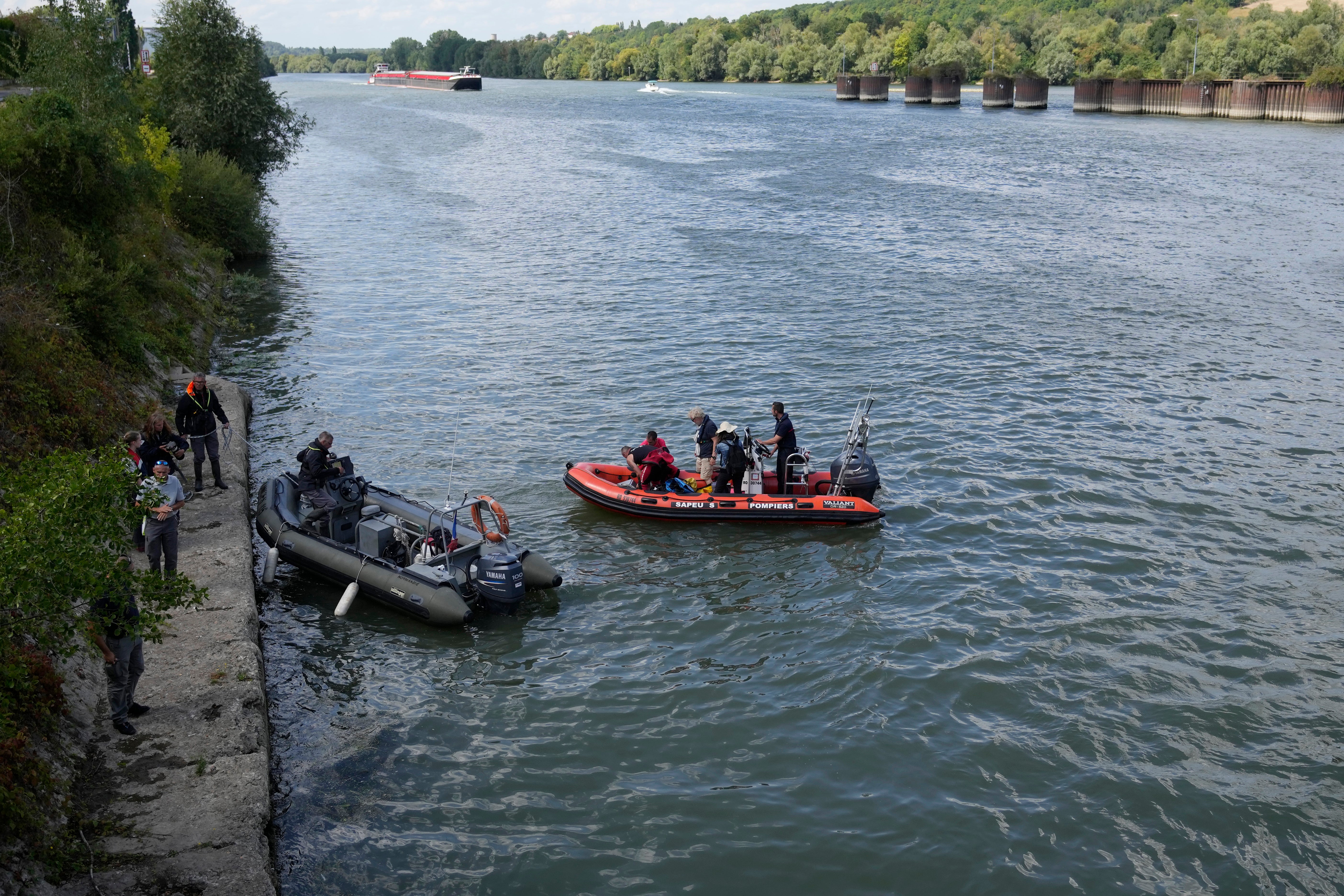 French fire brigade tracking on rubber boats a Beluga whale on the Seine river