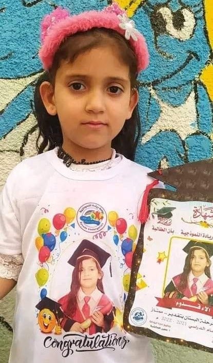 Alaa, 5, is pictured holding her kindergarten diploma