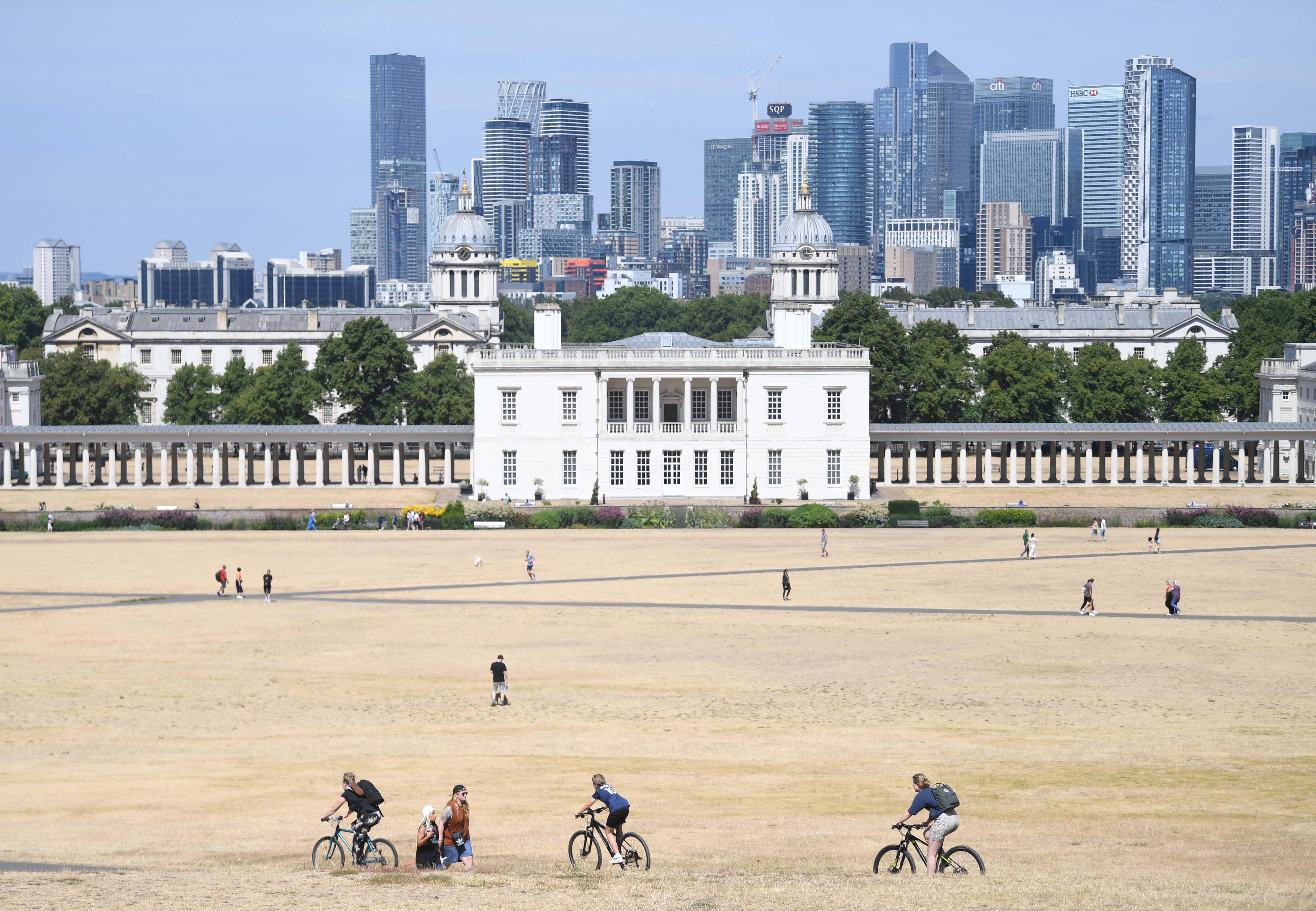 People walk on the parched grass in Greenwich Park in south-east London