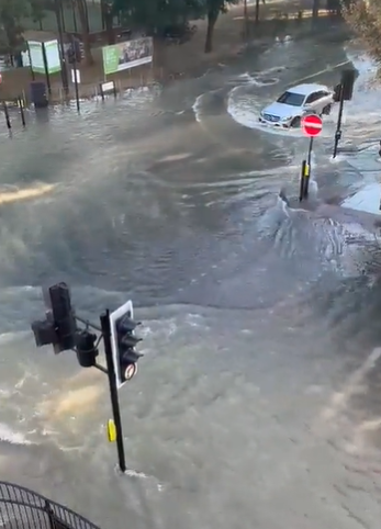 A car struggled to drive through the flooded street this morning