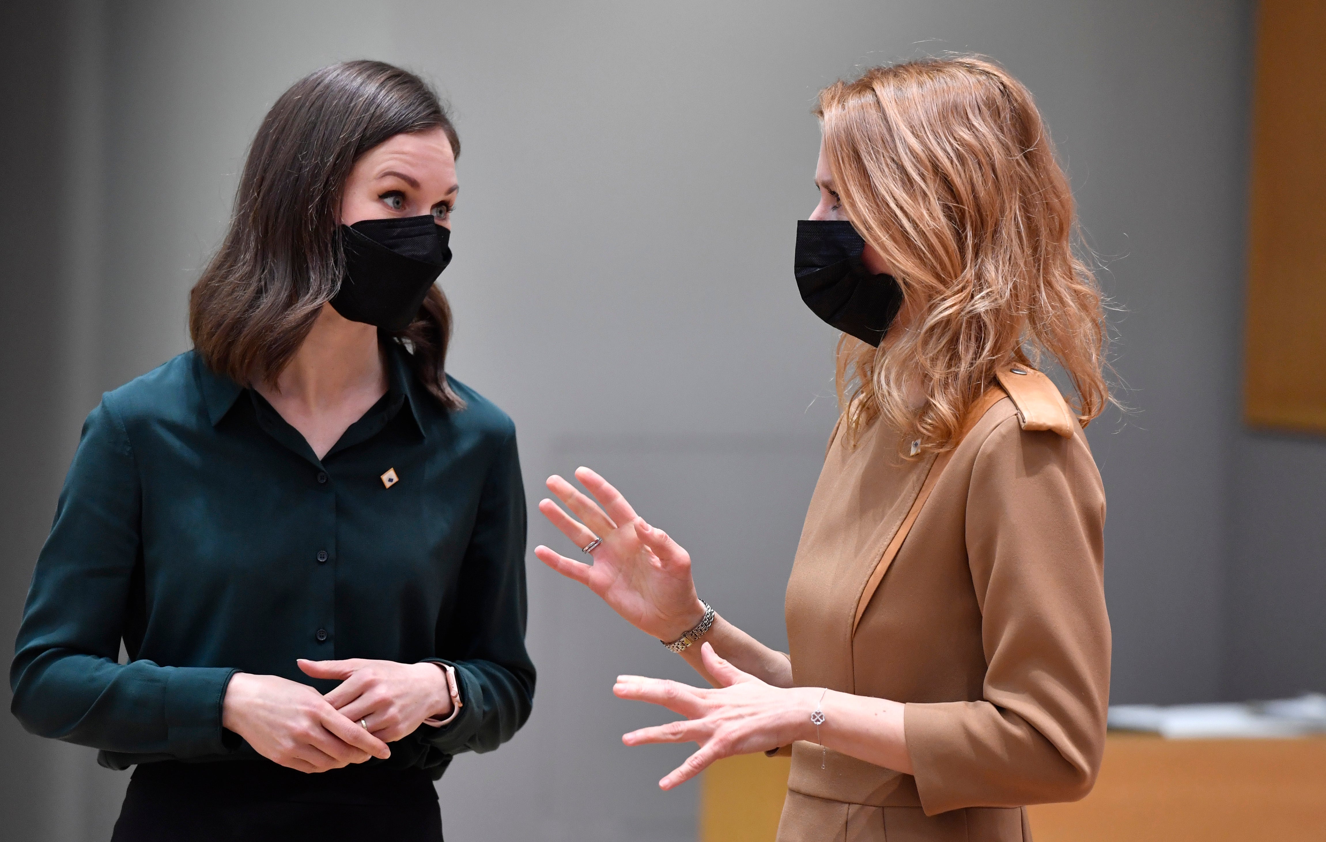 Finland’s prime minister Sanna Marin (L) speaks with her Estonian counterpart Kaja Kallas in Brussels on 15 December, 2021.